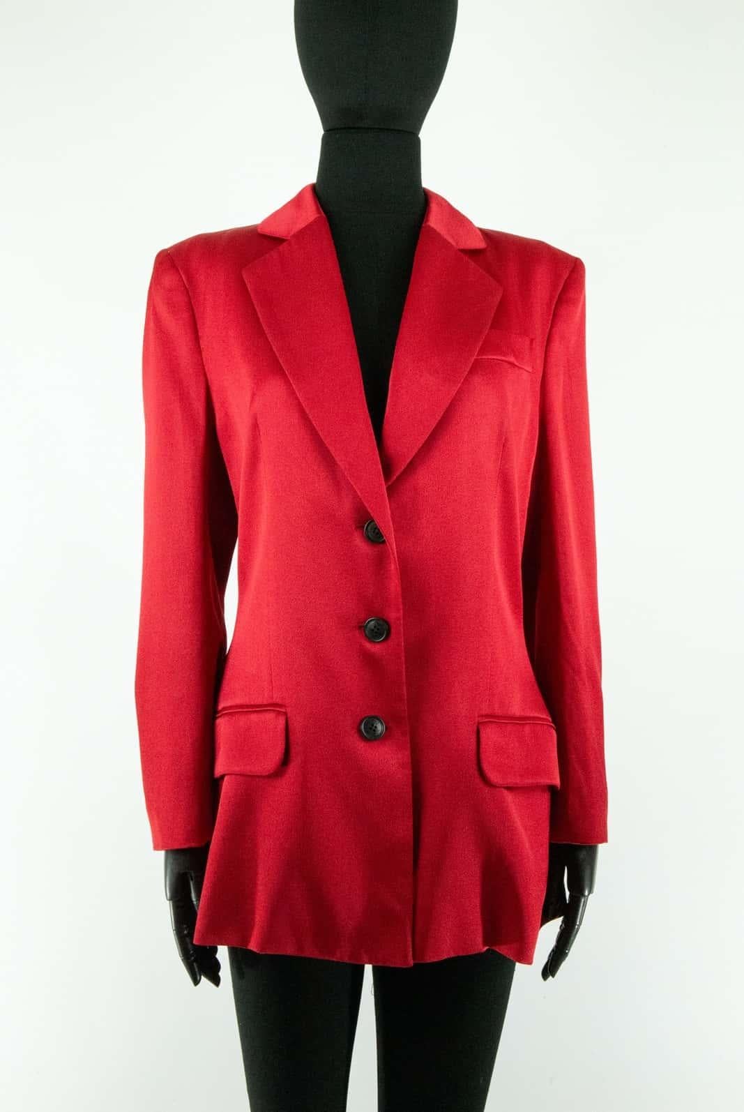 A red satin John Galliano A/W 2001 single-breasted blazer with black buttons embossed with the ‘John Galliano’ house logo up the front and on the cuff. At the front of the blazer are two covered pockets and one at the breast under the lapel. The cut
