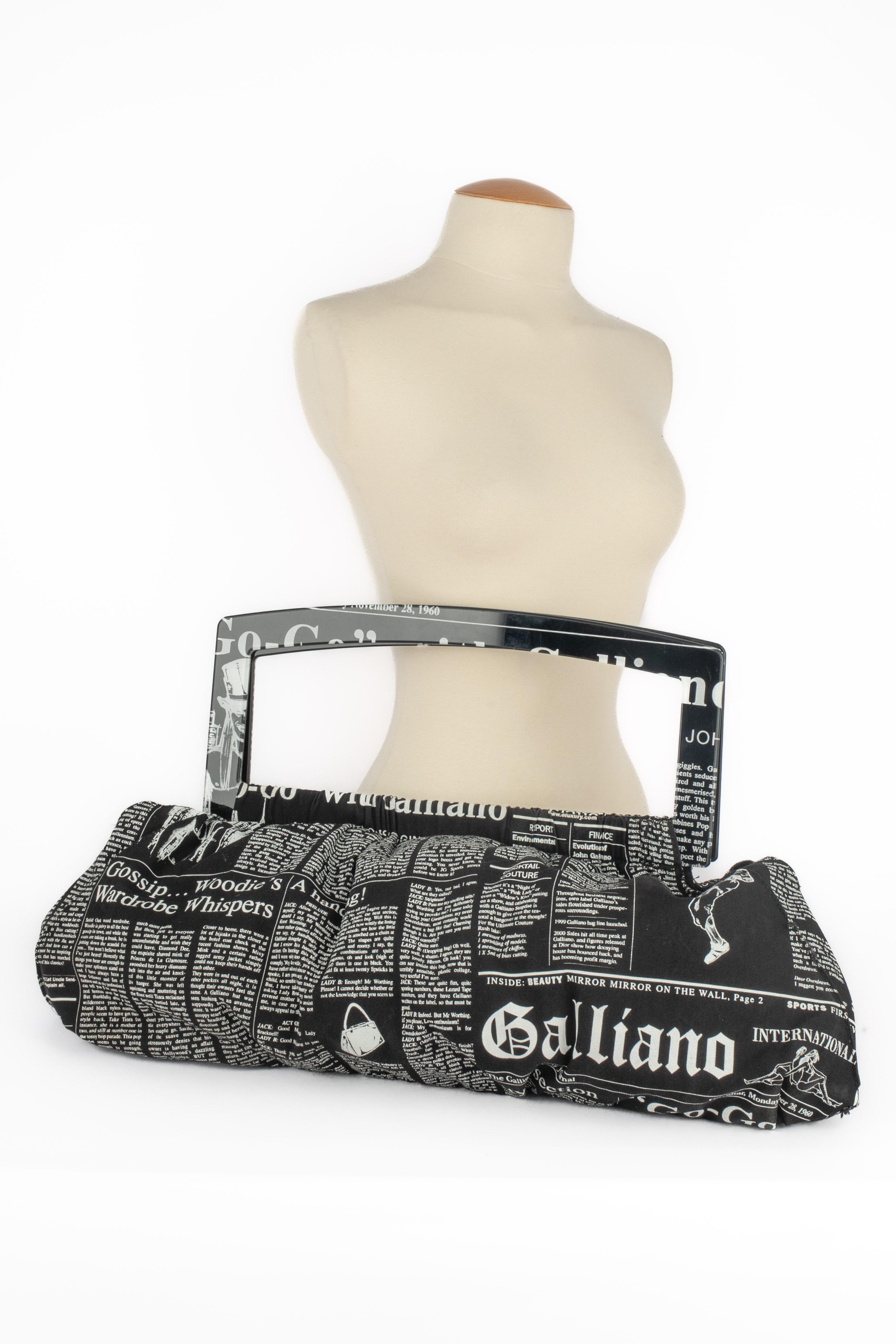 GALLIANO - (Fabriqué en Italie) Sac en coton noir et blanc avec un motif 'journal'. Manche XXL en bakélite.

Condit :
Très bon état.

Dimensions :
Longueur : 60 cm - Hauteur : 30 cm - Profondeur : 9 cm - Poignée : 70 cm

SKU:S115


