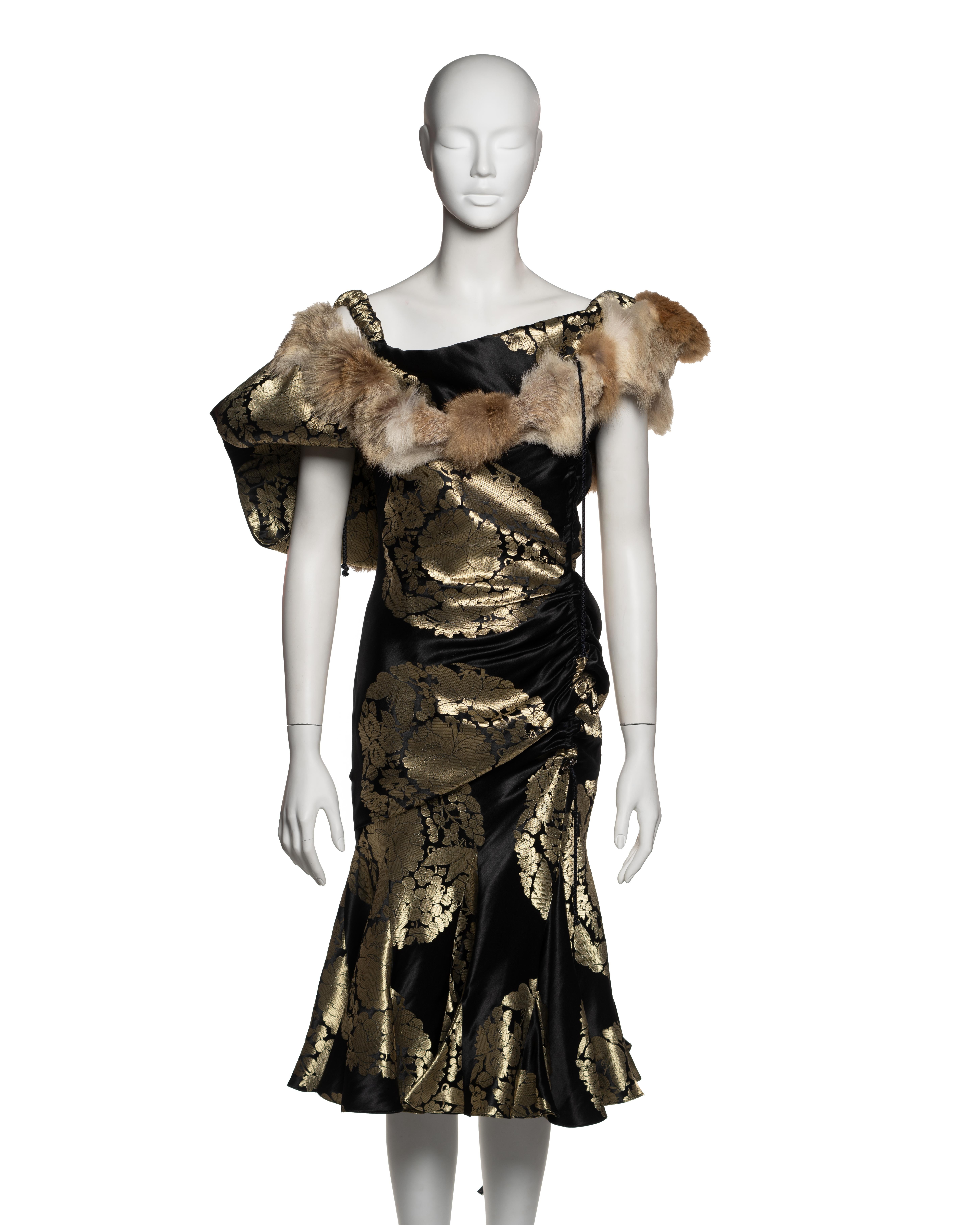 This John Galliano dress from the Fall-Winter 2002 collection exemplifies his ability to blend historical references with avant-garde design. Crafted from a black silk-blend brocade, the fabric is woven with gold roundels depicting floral and