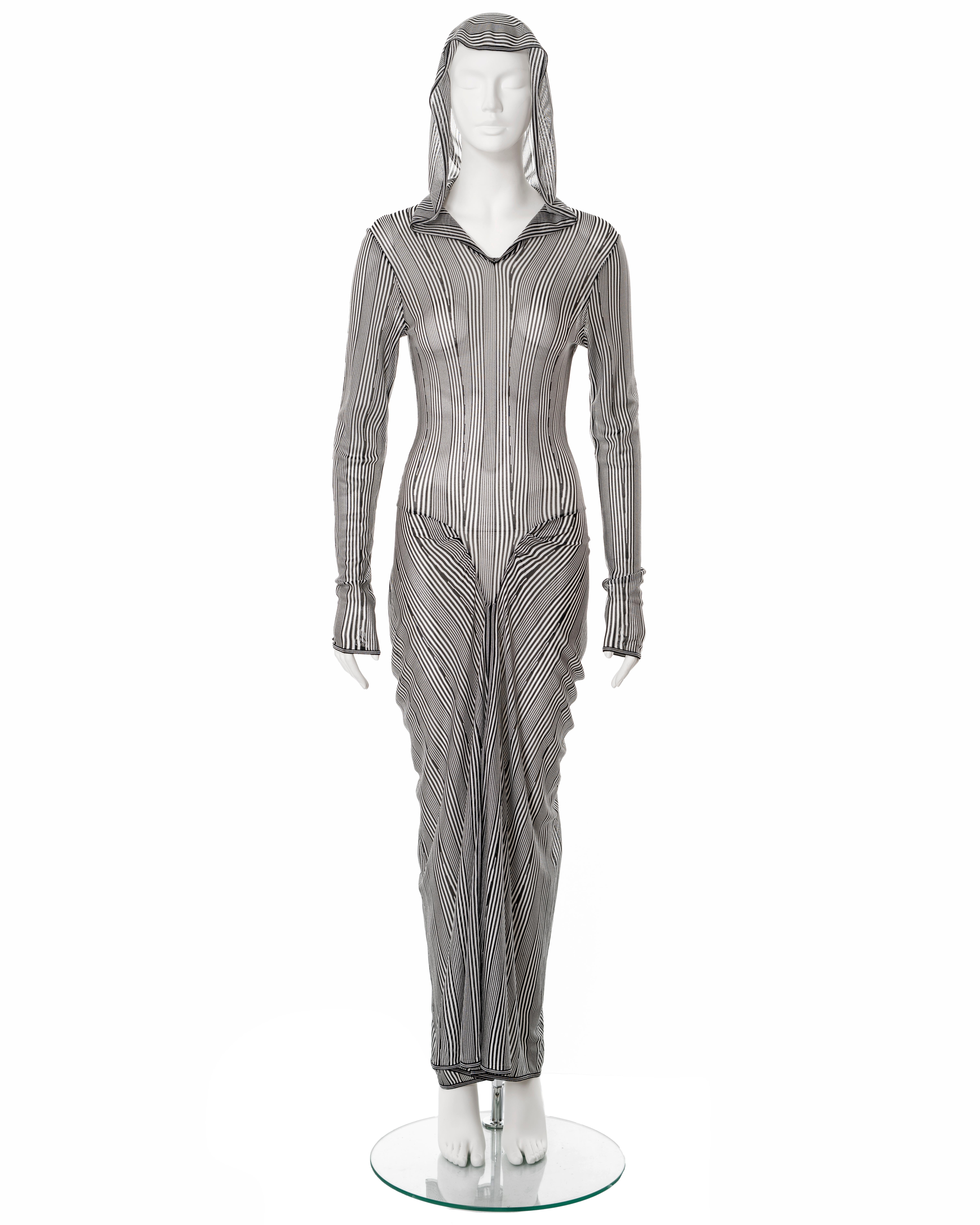 ▪ John Galliano hooded summer dress
▪ Sold by One of a Kind Archive
▪ Spring-Summer 2002
▪ Constructed from black and white striped viscose knit 
▪ Long fitted sleeves
▪ V-seams at the hips
▪ Draped maxi skirt
▪ Built-in mesh bodysuit 
▪ Size