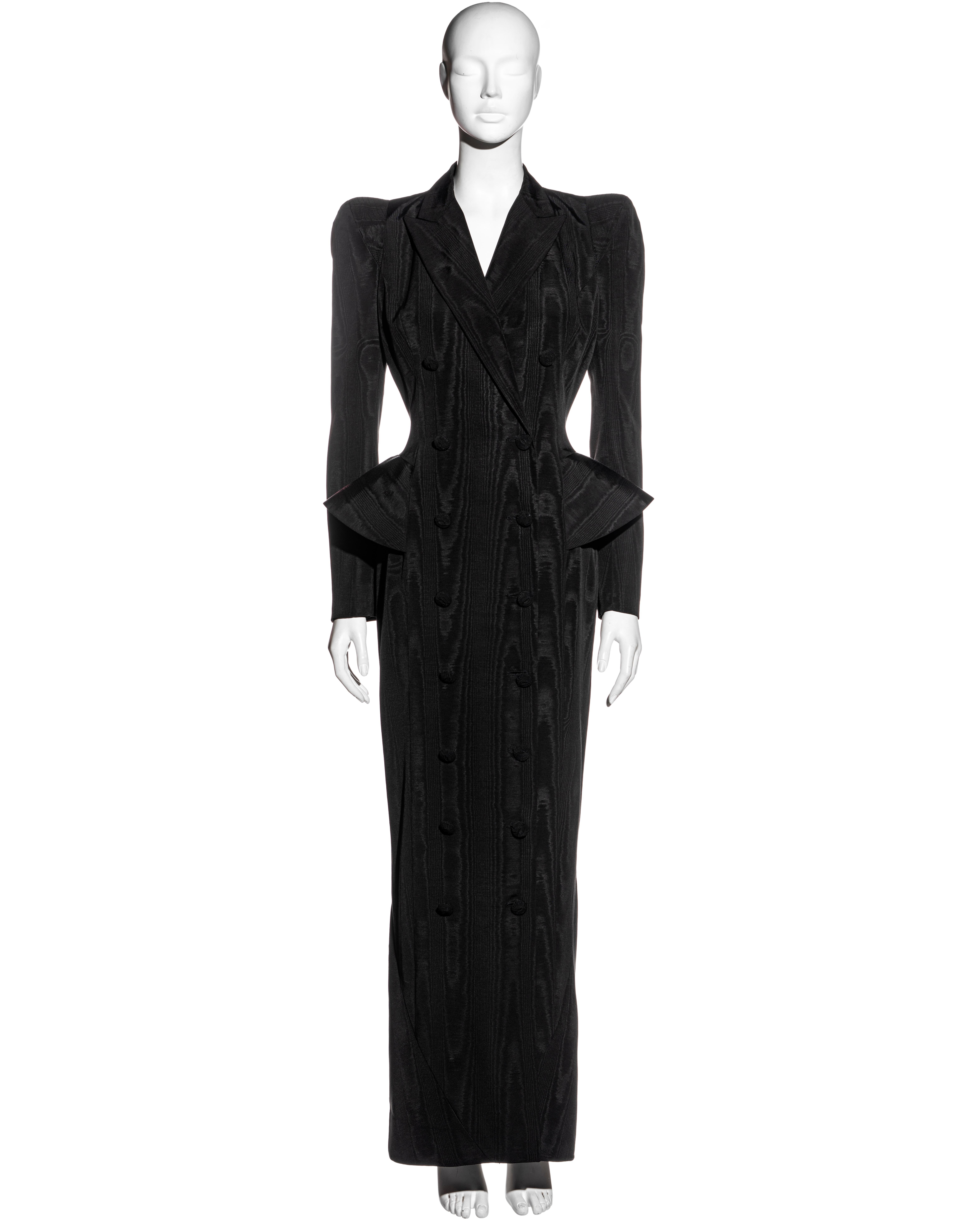 ▪ John Galliano black moiré double-breasted evening dress coat
▪ Pagoda shoulders
▪ Cord wrapped buttons
▪ Skirt back with cross-over scissor panels finishing as a peplum at the hips
▪ Peak lapels 
▪ Haute Couture quality
▪ Fully lined 
▪ 51%