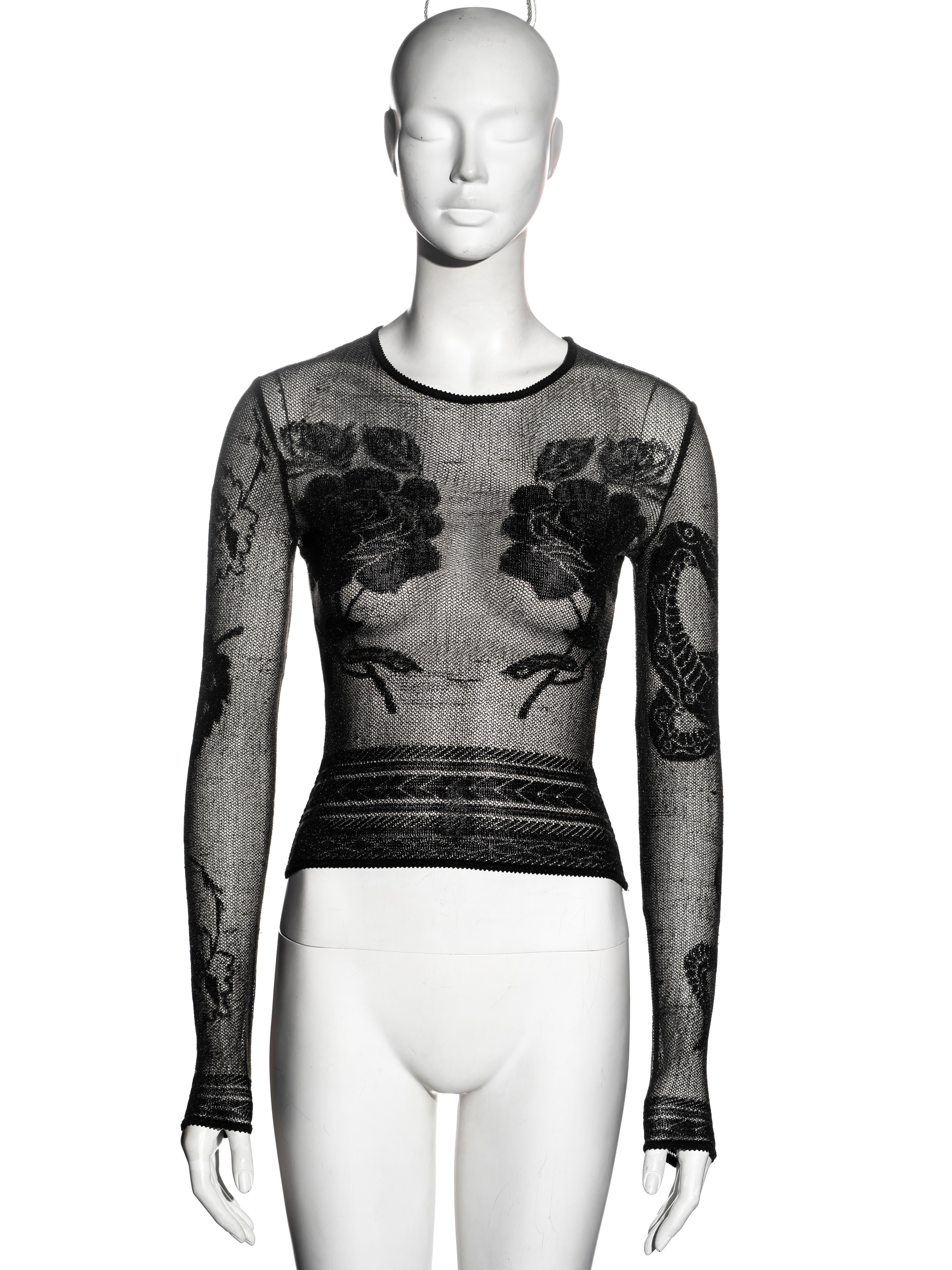 ▪ Rare John Galliano long-sleeve top
▪ Black sheer knit with tattoo designs 
▪ Skin-tight 
▪ Size Small
▪ Fall-Winter 1997
▪ Made in France