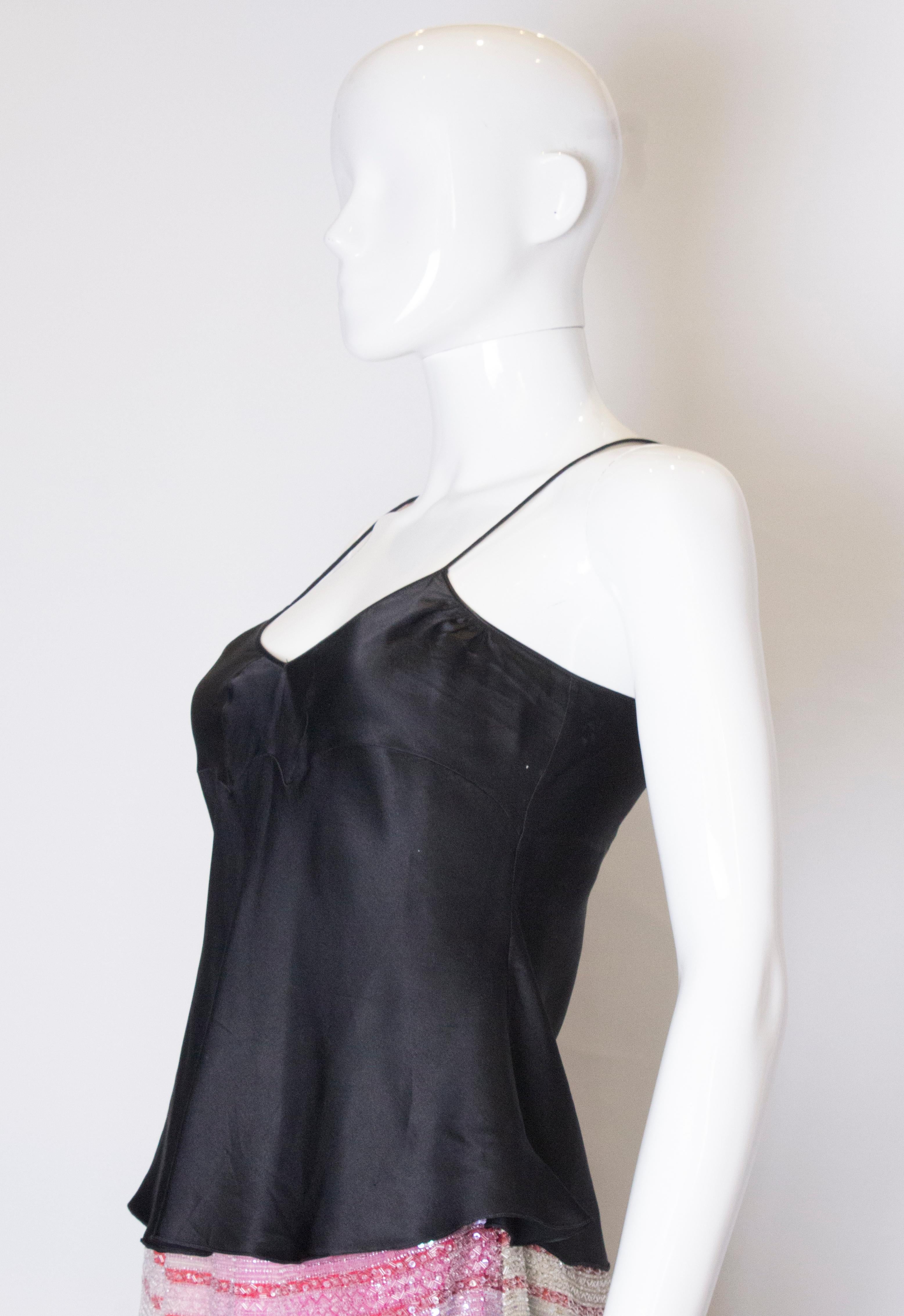 A pretty silk camisole by John Galliano. In black silk , the camisole has a fluted hem and spagetti straps. Size 36/4