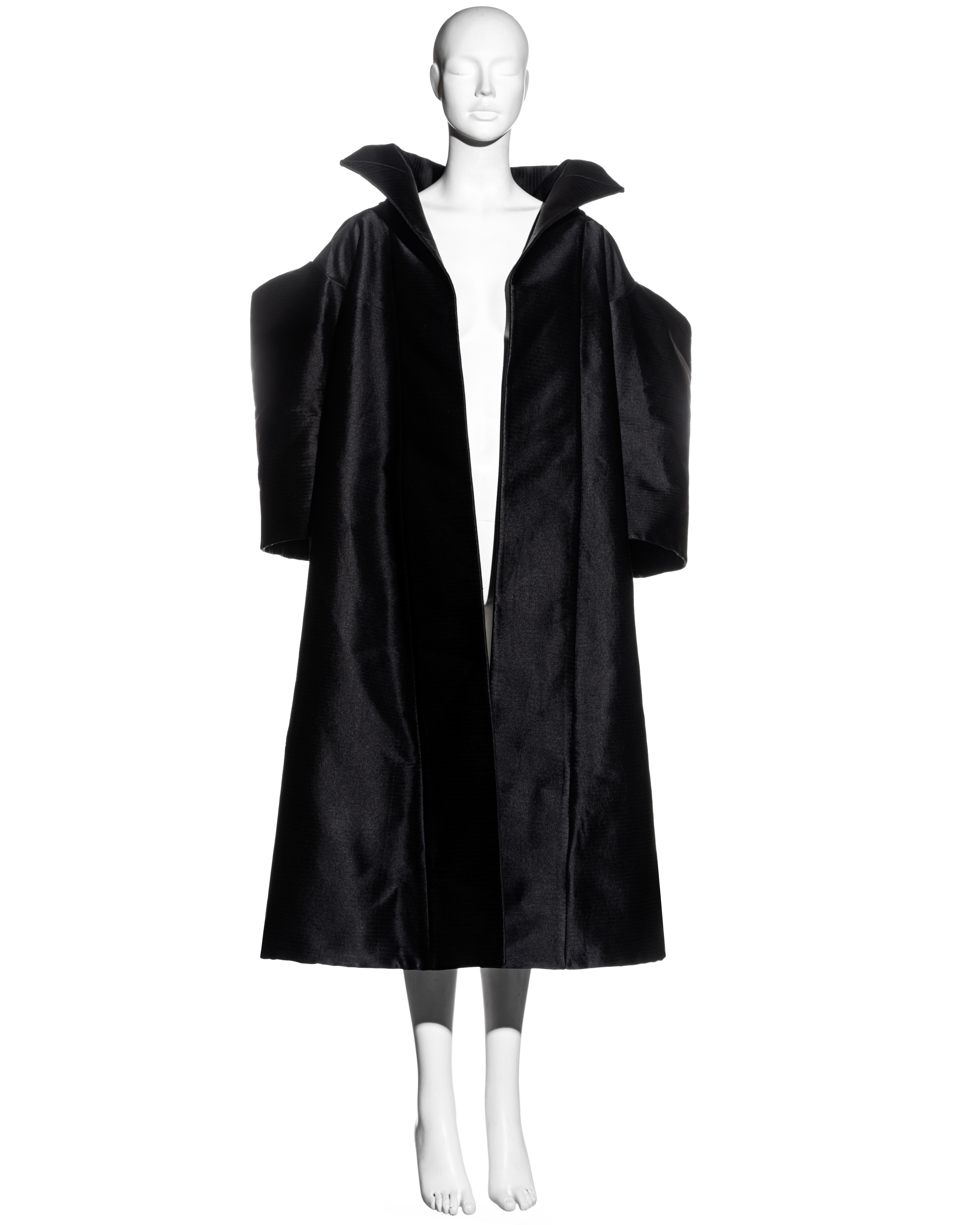 ▪ John Galliano black silk showpiece opera coat 
▪ Heavyweight 
▪ Standing collar 
▪ Allover parallel topstitch designed to add structure and volume to the fabric
▪ Cube shoulders and wide-cut sleeves 
▪ Silk lining 
▪ Haute Couture quality
▪ 100%