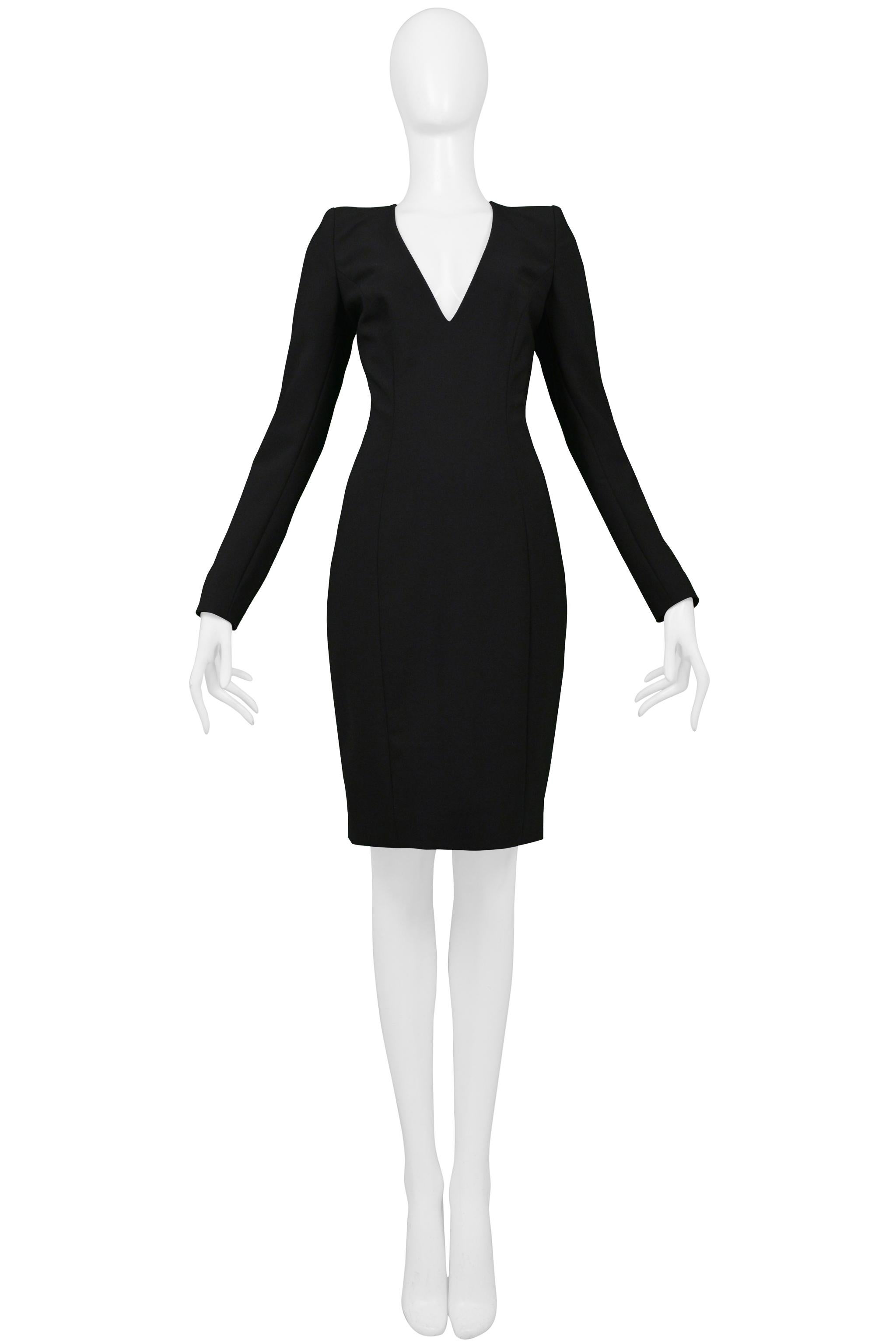 Resurrection is excited to offer a stunning vintage John Galliano black widow cocktail dress featuring a deep V neckline, long sleeves with covered buttons, shoulder pads, curved seams, and a fitted body. From the 1997 collection.

John