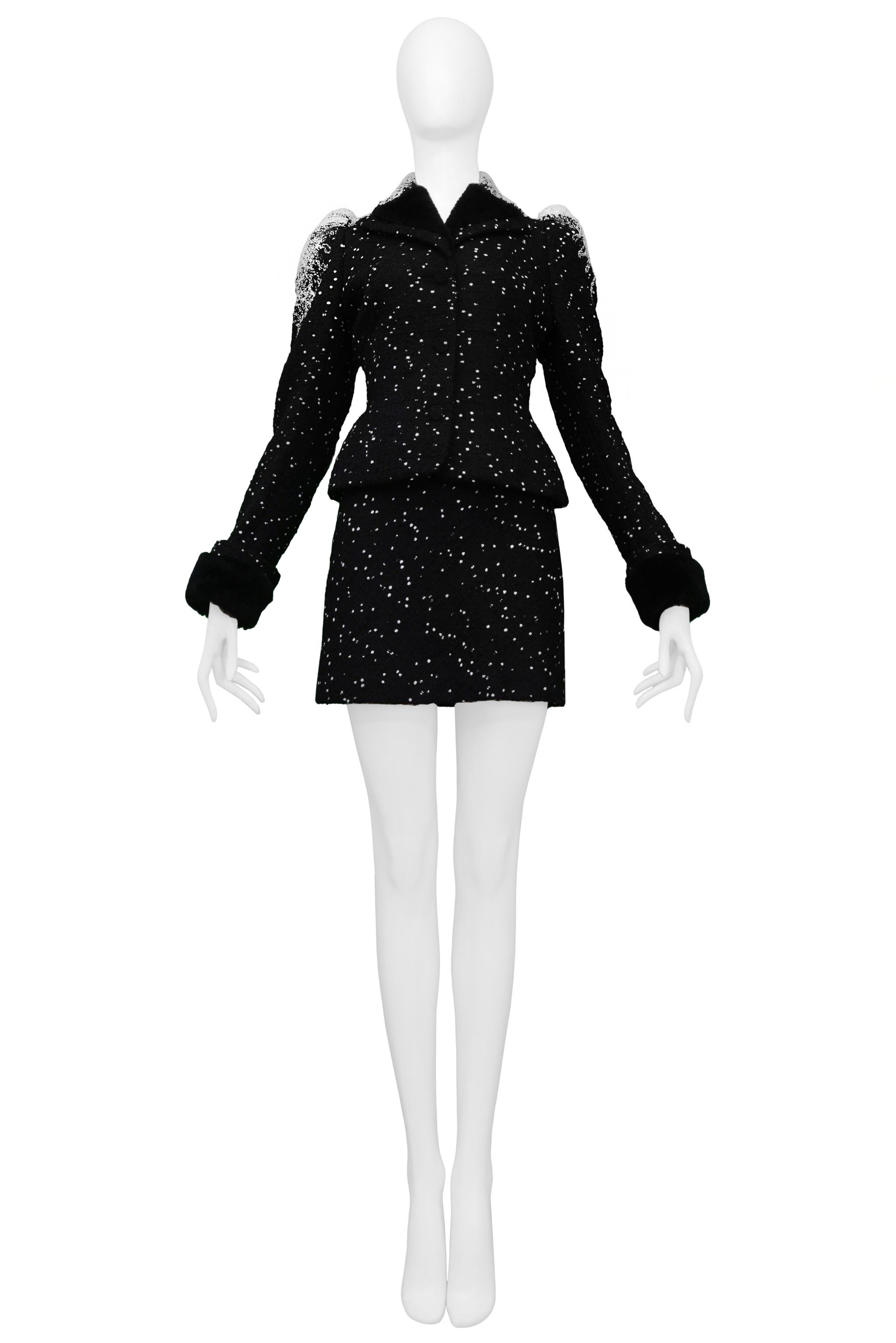 Resurrection Vintage is pleased to offer a vintage John Galliano black and white skirt suit featuring a fitted jacket with white stitching all over the shoulders, front buttons, and flared peplum. The skirt features a mini body and a side