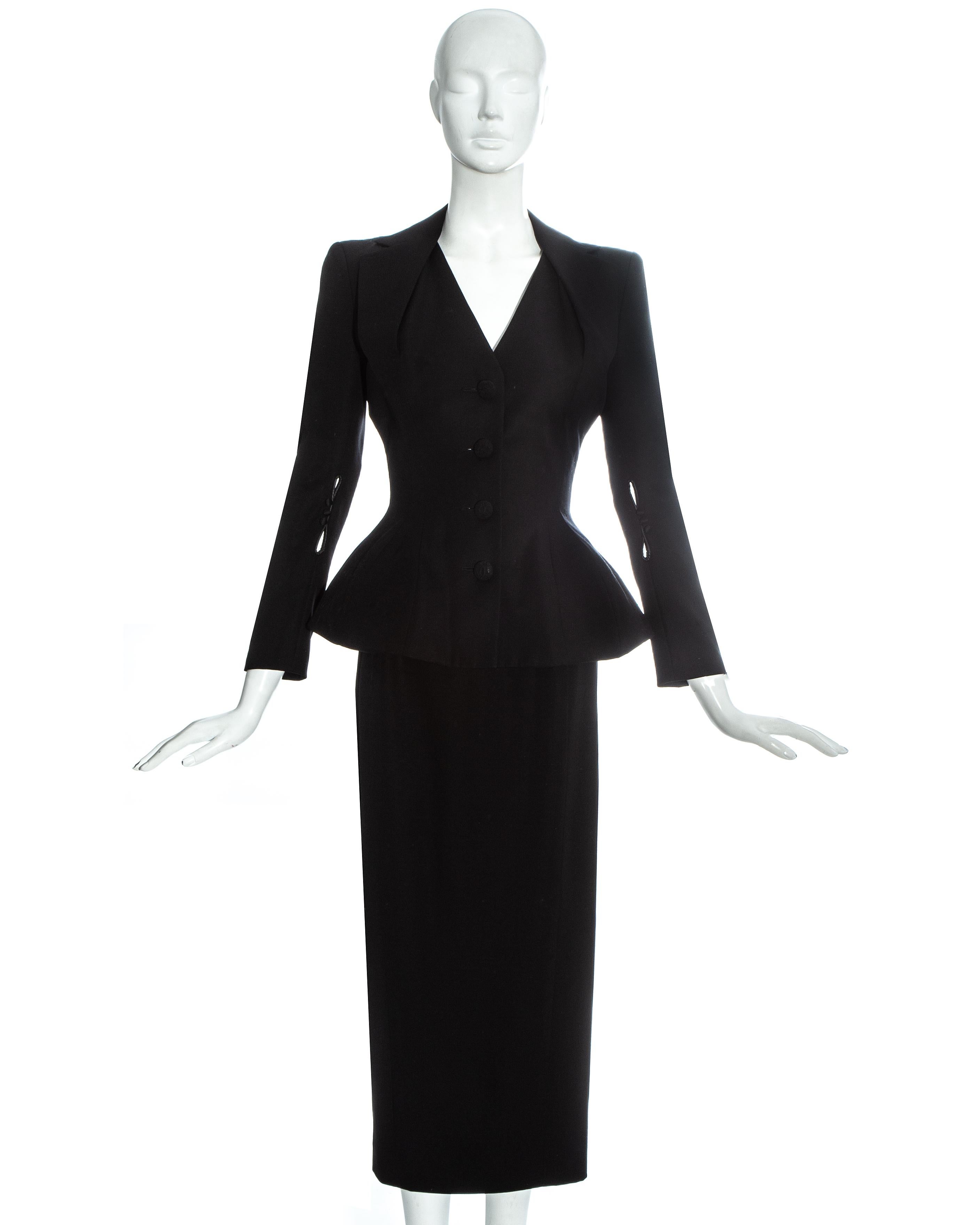 John Galliano black wool 'Pin Up' skirt suit. Jacket with padded shoulders, hips and halter-neck style lapel, cord covered buttons. Matching high-waisted pencil skirt with back slit.   

Misia Diva, Spring-Summer 1995 
