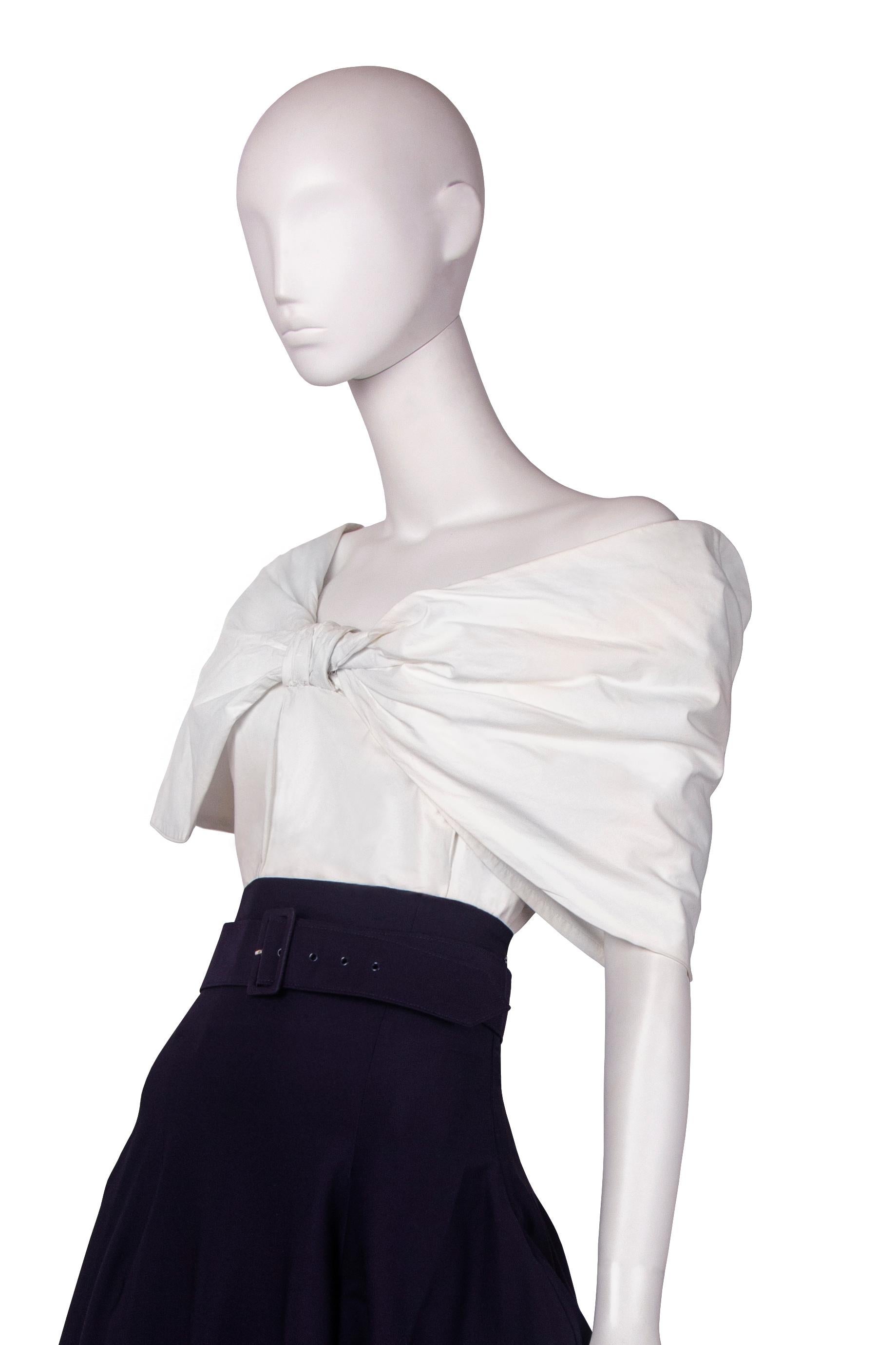 This John Galliano runway ensemble from Spring-Summer 1988 ‘Blanche Dubois’ combines two main themes from the collection: the bow and polonaise skirt. 

The bodice is made of cotton with rigilene boning and features a large frontal bow, the hero
