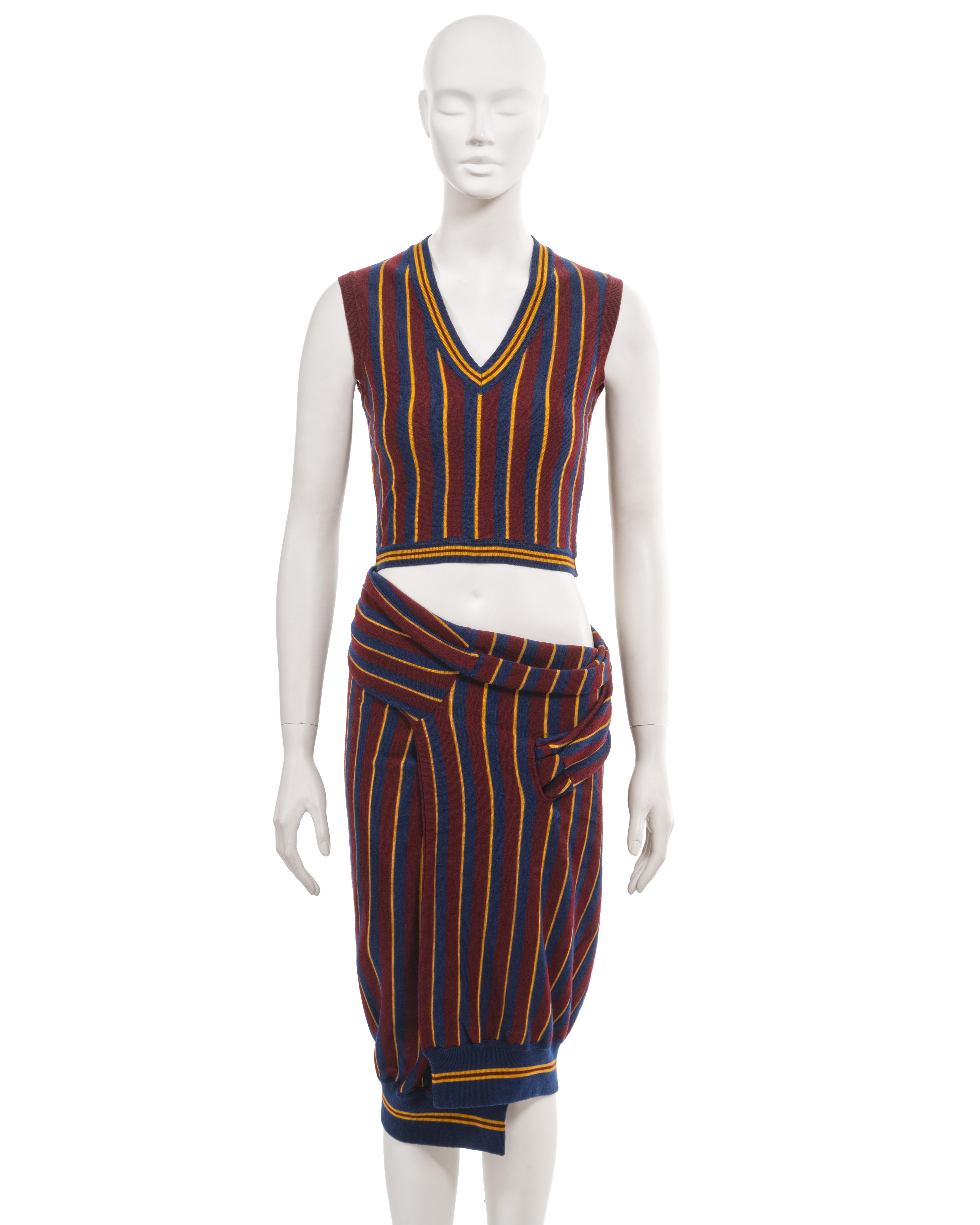 ▪ Archival John Galliano 2 piece set
▪ 'Suzy Sphinx' collection, Fall-Winter 1997
▪ Sold by One of a Kind Archive
▪ Burgundy wool jersey with woven navy and mustard stripes. Inspired by English school uniforms
▪ Ribbed wool jersey trim with