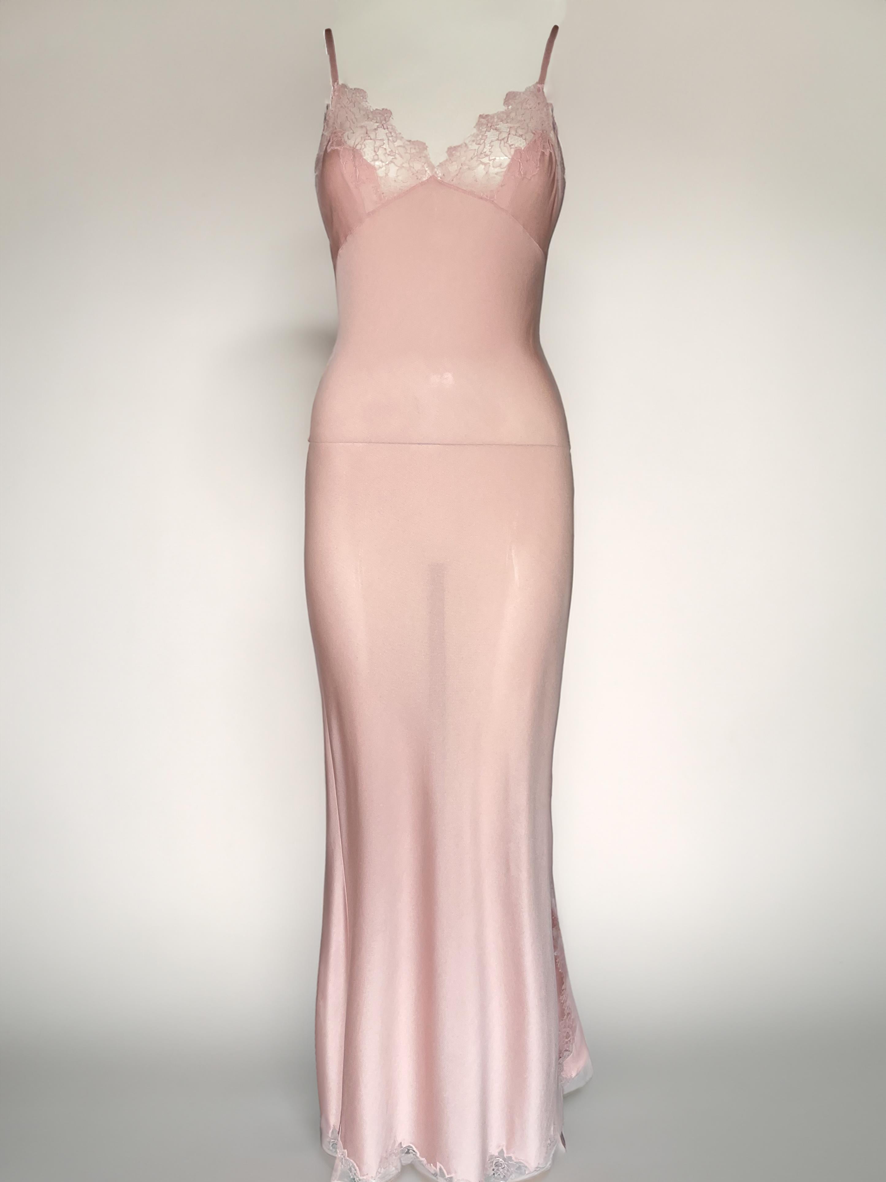 Un raro abito sottoveste di ispirazione boudoir della collezione Autunno/Inverno 2000 di John Galliano for Christian Dior. Realizzato in maglia elastica rosa pallido con delicati dettagli in pizzo sul busto e sull'orlo. Presenta un'elegante spacco