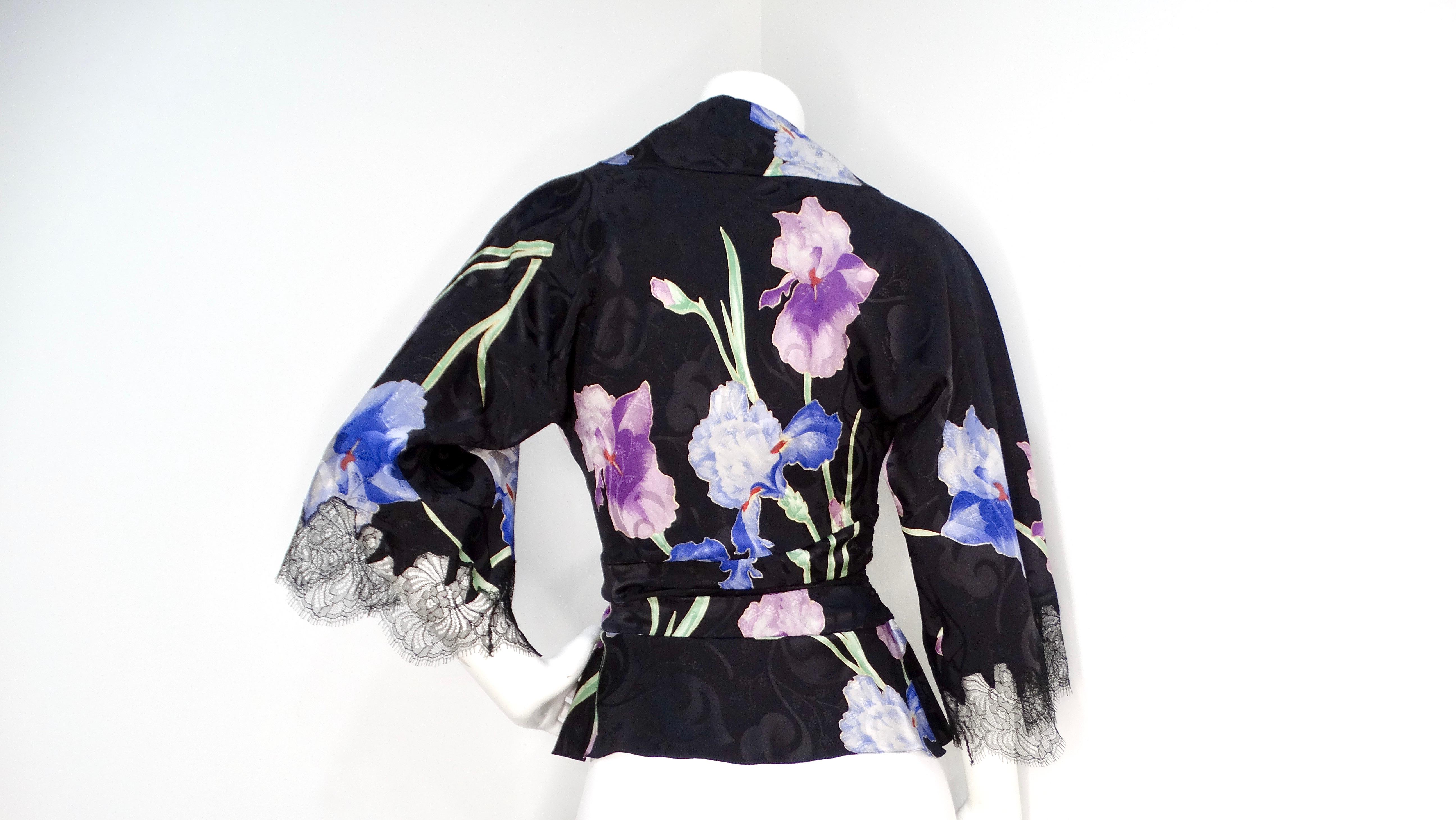 The John Galliano 2005 Black Kimono Style Floral Silk Top is a stunning example of the designer's flair for dramatic elegance and romantic detail. Crafted from luxurious black silk, this top features a captivating pattern of delicate purple and blue