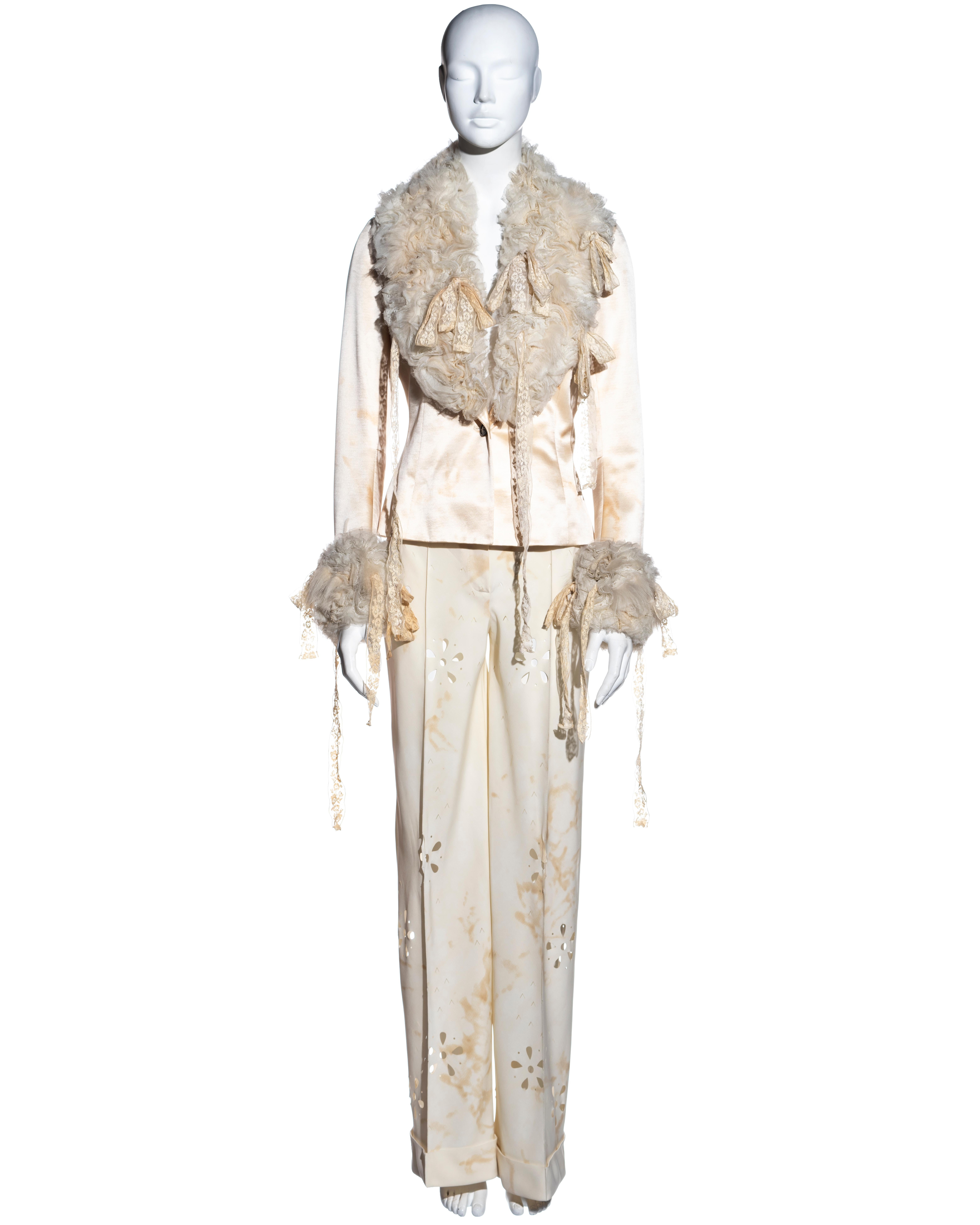 ▪ John Galliano cream silk pantsuit 
▪ Single-breast jacket with large collar and cuffs of ruffled antique lace ribbons and Mongolian lamb 
▪ Wide-leg pants with turn-ups and laser cut-outs 
▪ Designed with tea stains throughout to make the garment