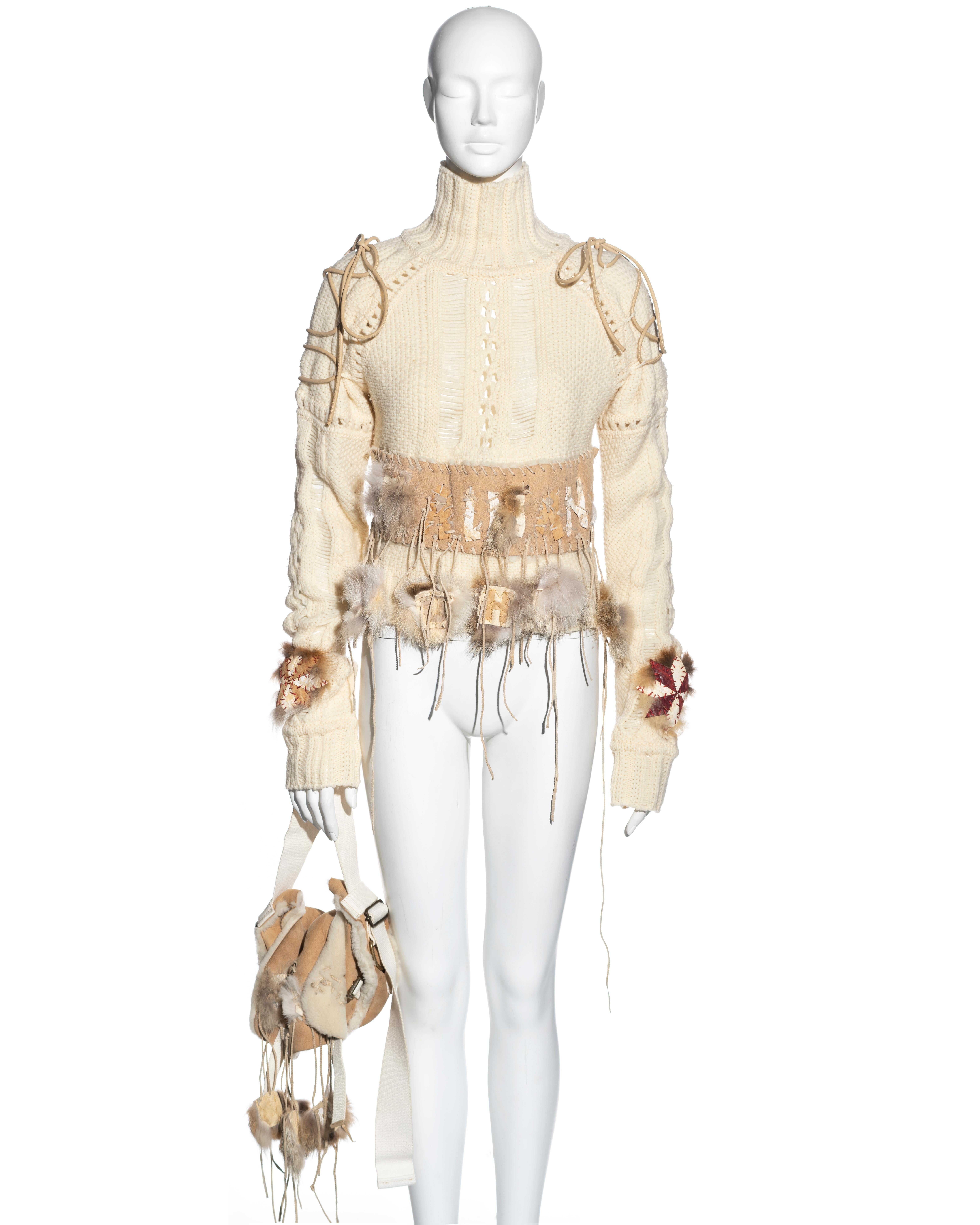 ▪ John Galliano sweater and bag set
▪ Sold by One of a Kind Archive
▪ Cream knitted wool turtleneck sweater 
▪ Leather lacing at the shoulders 
▪ Patchwork leather and suede appliqués 
▪ Matching shearling bag with canvas shoulder strap 
▪ Size: