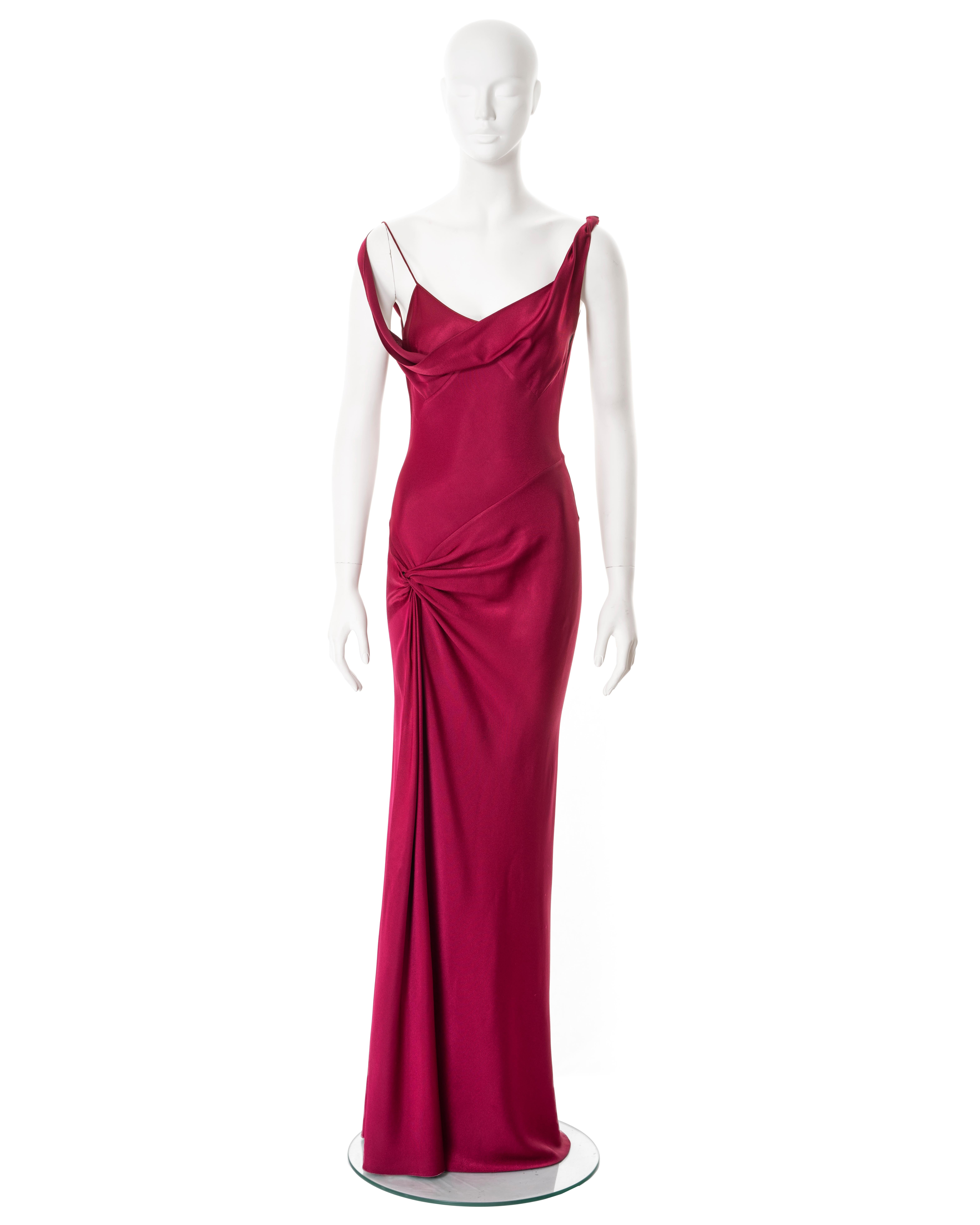 ▪ John Galliano evening dress
▪ Sold by One of a Kind Archive
▪ Fall-Winter 1999
▪ Constructed from crimson bias-cut crêpe backed satin
▪ Bodice with v-neck and spaghetti straps and draped cowl overlay with twisted off-shoulder straps 
▪ Knot detail