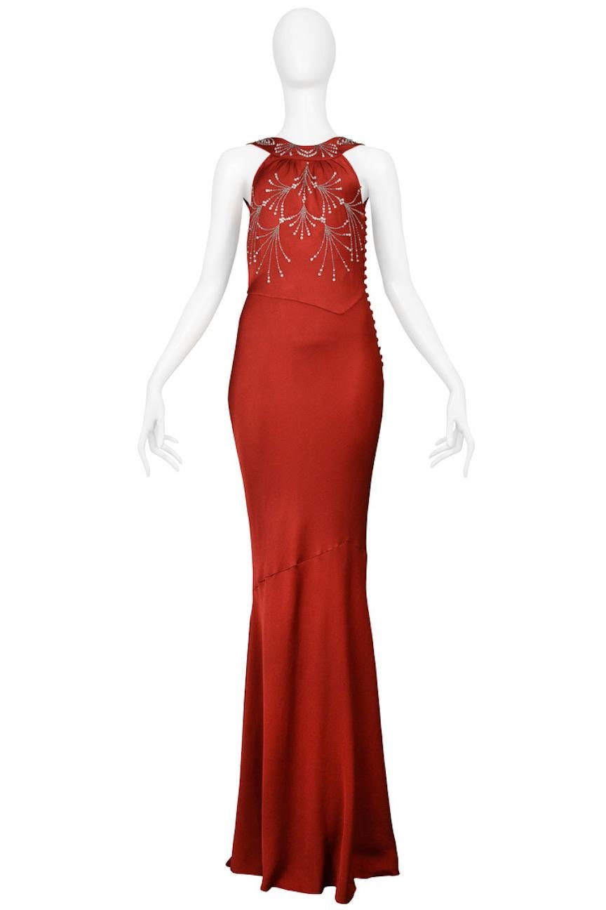 Resurrection Vintage is excited to offer a vintage John Galliano dark red satin evening gown featuring wide straps, open back with cowl, bias cut, signature covered buttons, clear rhinestones on front bodice, and gown length. 

John Galliano
Size: