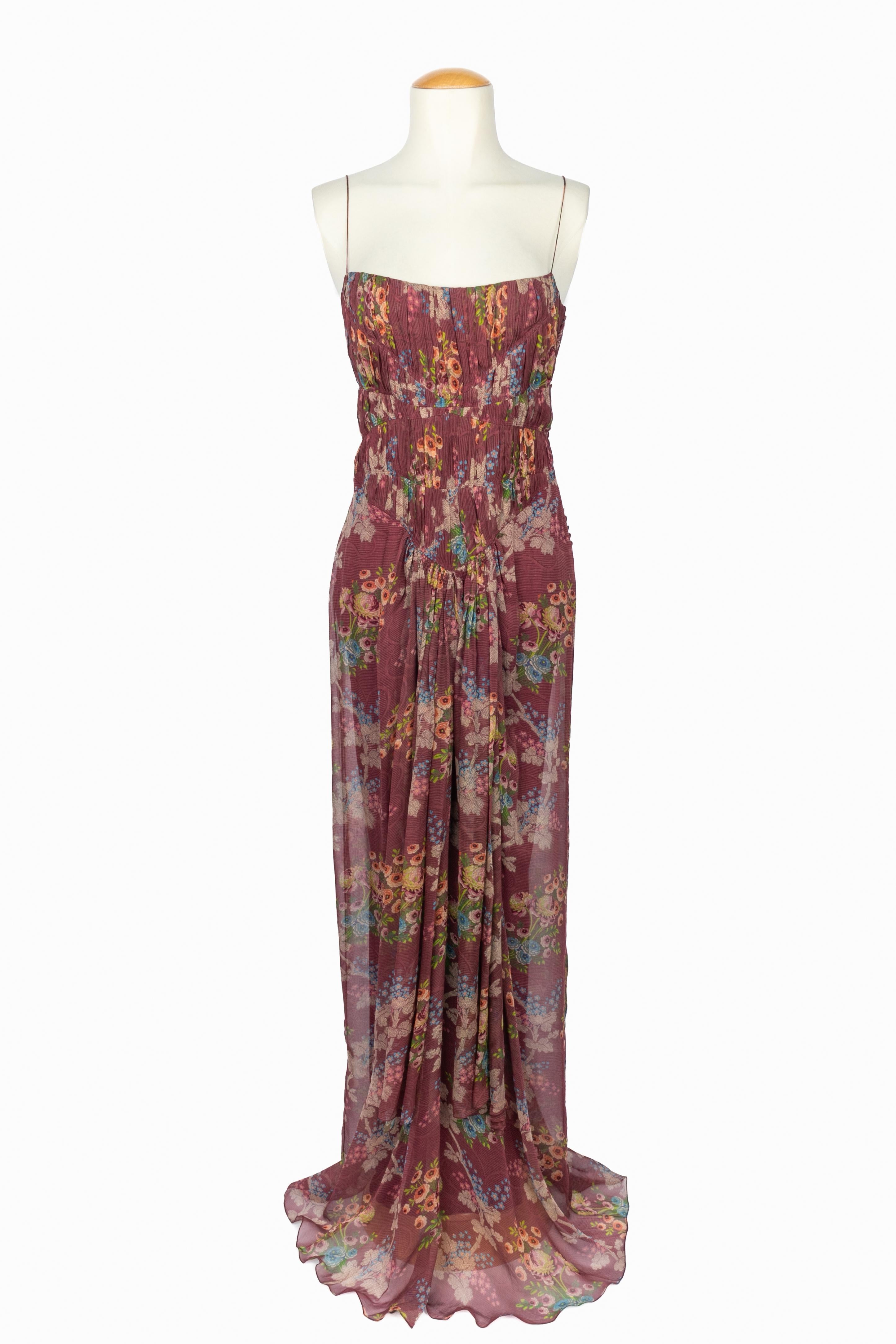 GALLIANO - (Made in France) Langes Kleid mit dünnen Trägern aus bedrucktem Seidenchiffon mit Blumenmotiv auf violettem Grund. Plissiertes Mieder. Ready-to-Wear-Kollektion 