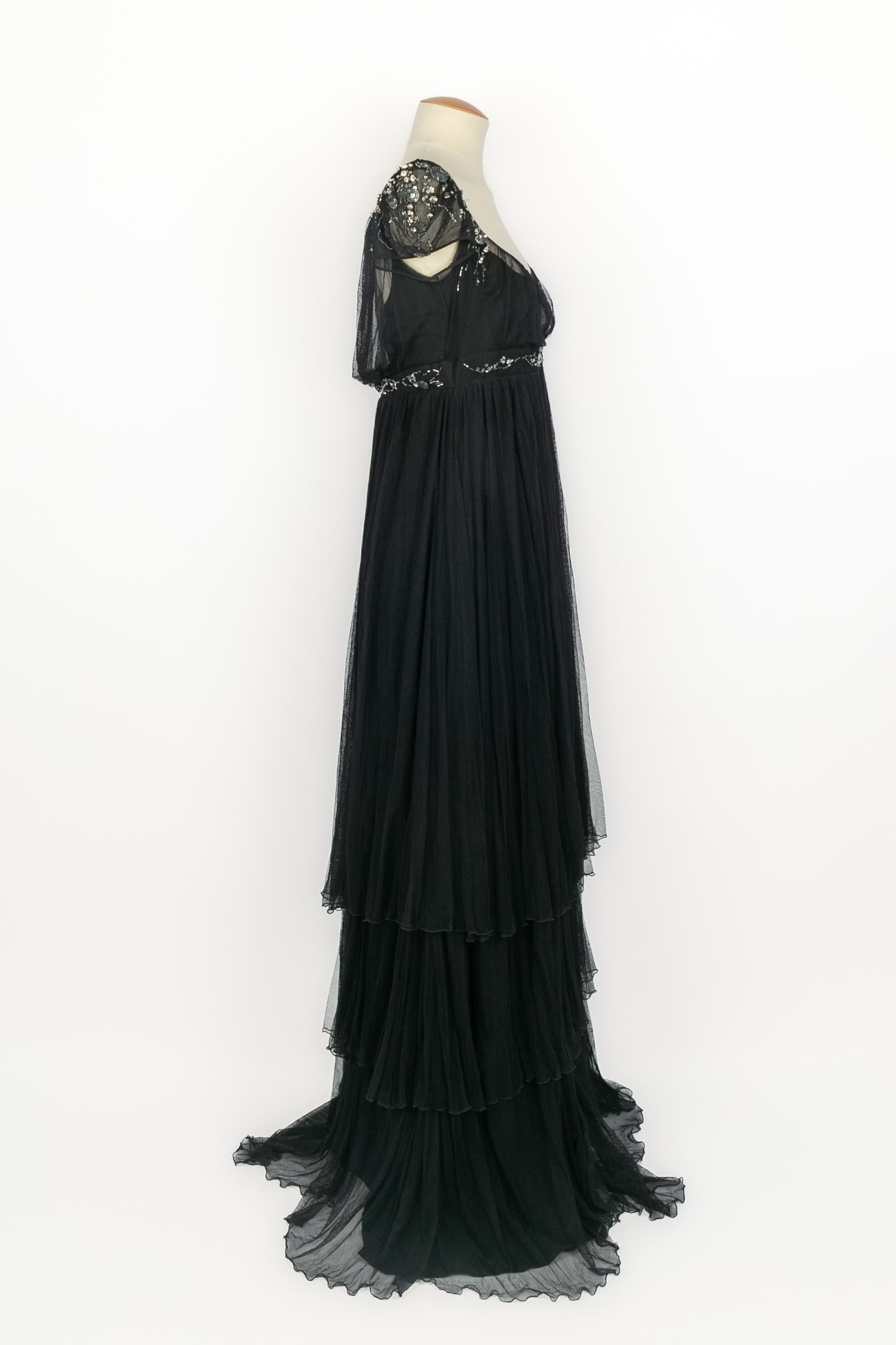 John Galliano - (Made in France) Abito lungo nero in seta e tulle con maniche corte. Vita e maniche ricamate con perle, paillettes e strass. Indica la taglia 44FR. Collezione Autunno-Inverno 2007.

Condizioni:
Ottime condizioni

Dimensioni:
Petto: