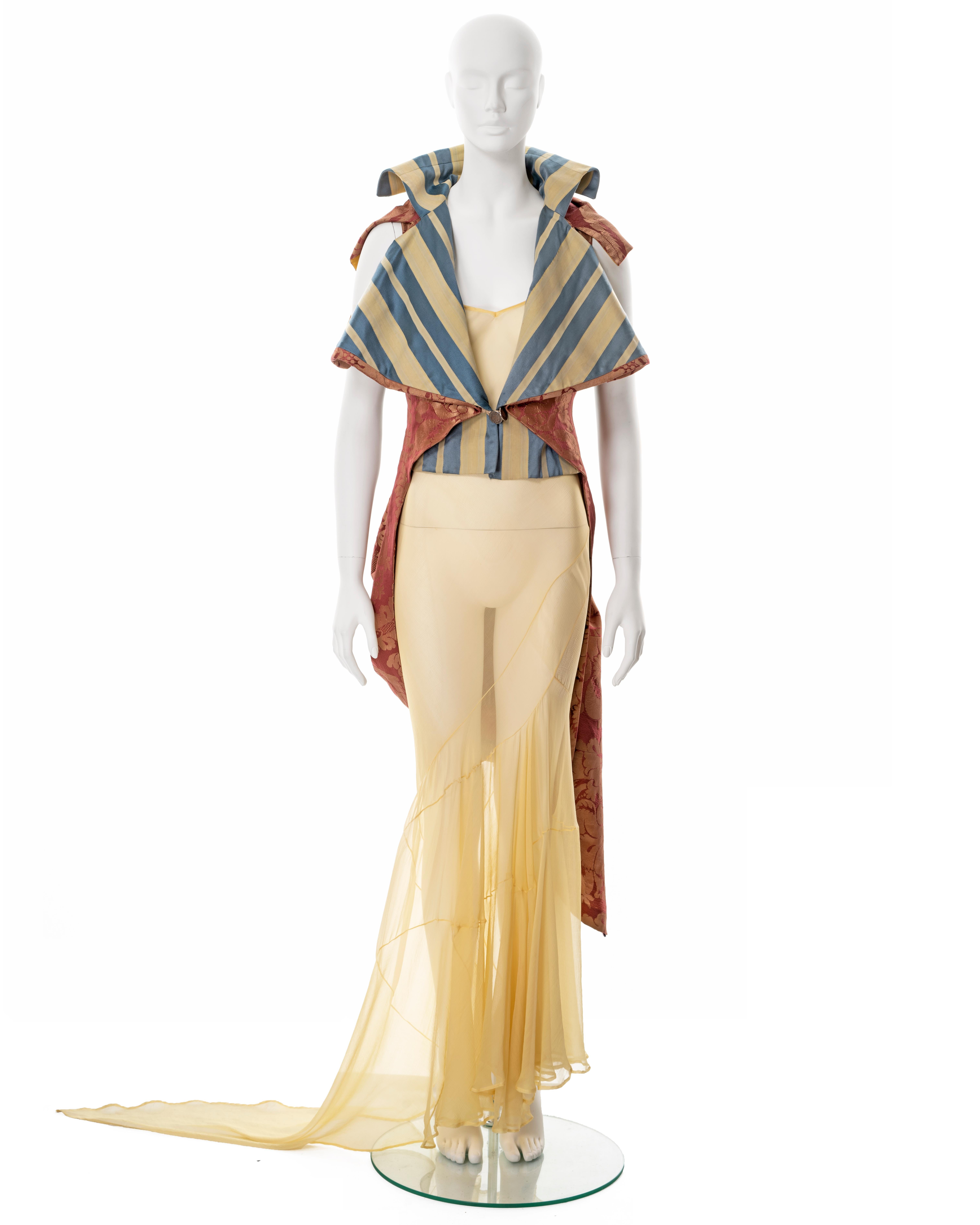 ▪ John Galliano 'Filibuster' runway ensemble 
▪ Sold by One of a Kind Archive
▪ Spring-Summer 1993
▪ Museum piece
▪ Sleeveless tailcoat constructed from furnishing-weight amber Rubelli silk damask and pale yellow and blue striped satin
▪ Back panel