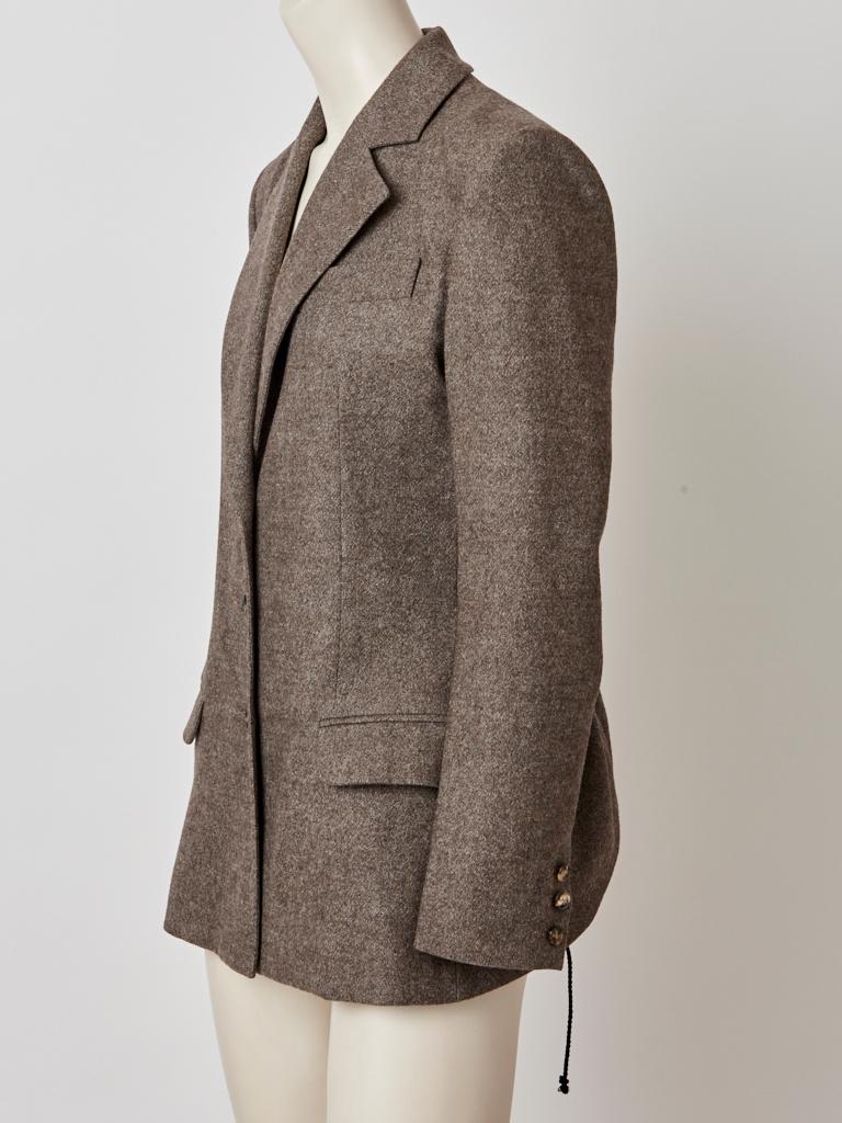 John Galliano, brown, heather, wool flannel, fitted, blazer/jacket having a three button closure, narrow lapels, flap pockets, and a drawstring, ruched back detail inspired from a Victorian bustle.
