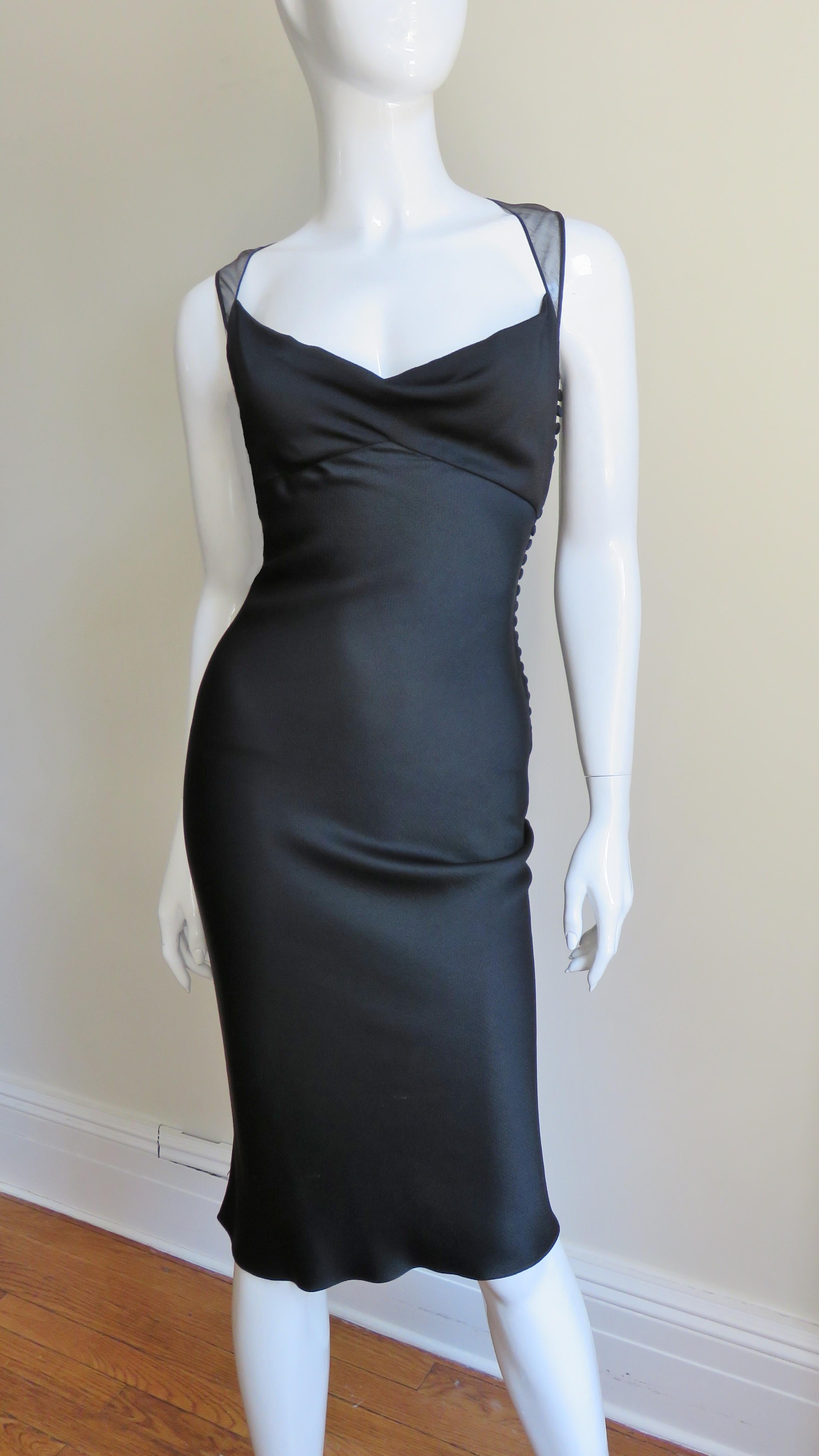 A beautiful black silk dress from John Galliano for Christian Dior.  It is fitted with a front bust crossing inset sweetheart neckline with sheer straps forming a sheer low V back.  The dress conforms to the wearer due to it's bias cut and the skirt