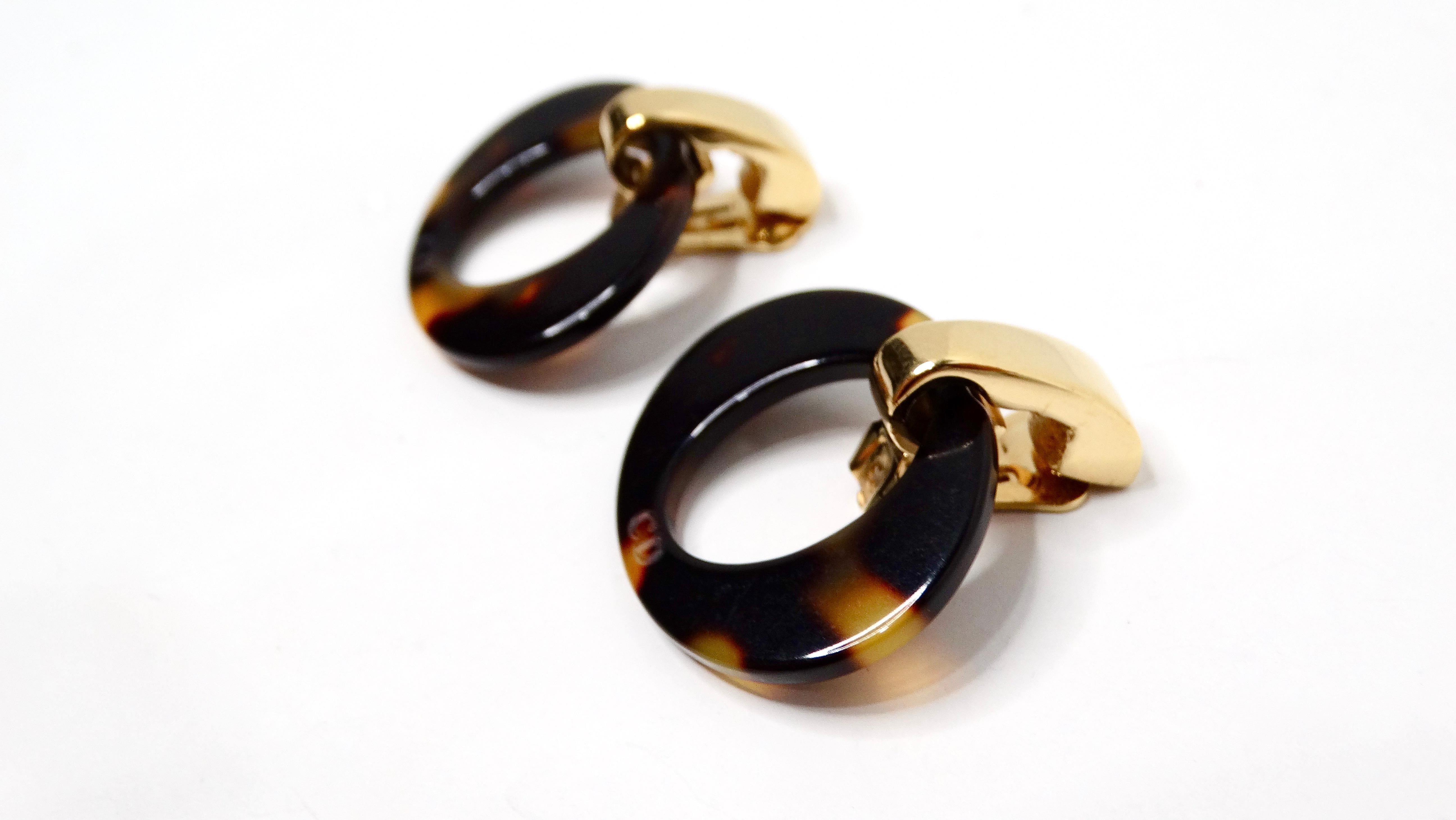 The Y2K John Galliano for Christian Dior Tortoise Clip-On Hoop Earrings are a stunning example of vintage-inspired luxury jewelry that seamlessly blends bold design with sophisticated elegance. Crafted in an oval shape, these earrings feature a