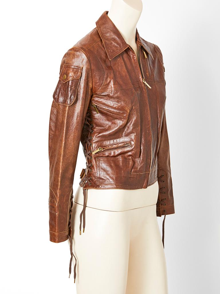 John Galliano for Christian Dior, brown, distressed  leather, fitted, cropped jacket, having small flap pockets at the shoulders, slanted zipper compartments at the bust, hip and cuffs and lacing detail at the sleeves and sides. 