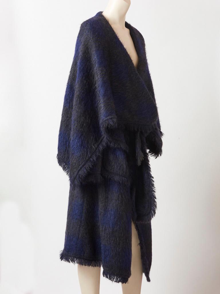 John Galliano, Charcoal grey and midnight blue, mohair blanket coat having fringed detail at the collar, cuffs, pockets, and hem. This coat is soft, having no structure, which can wrap around the body like a blanket . It has a belt with a huge