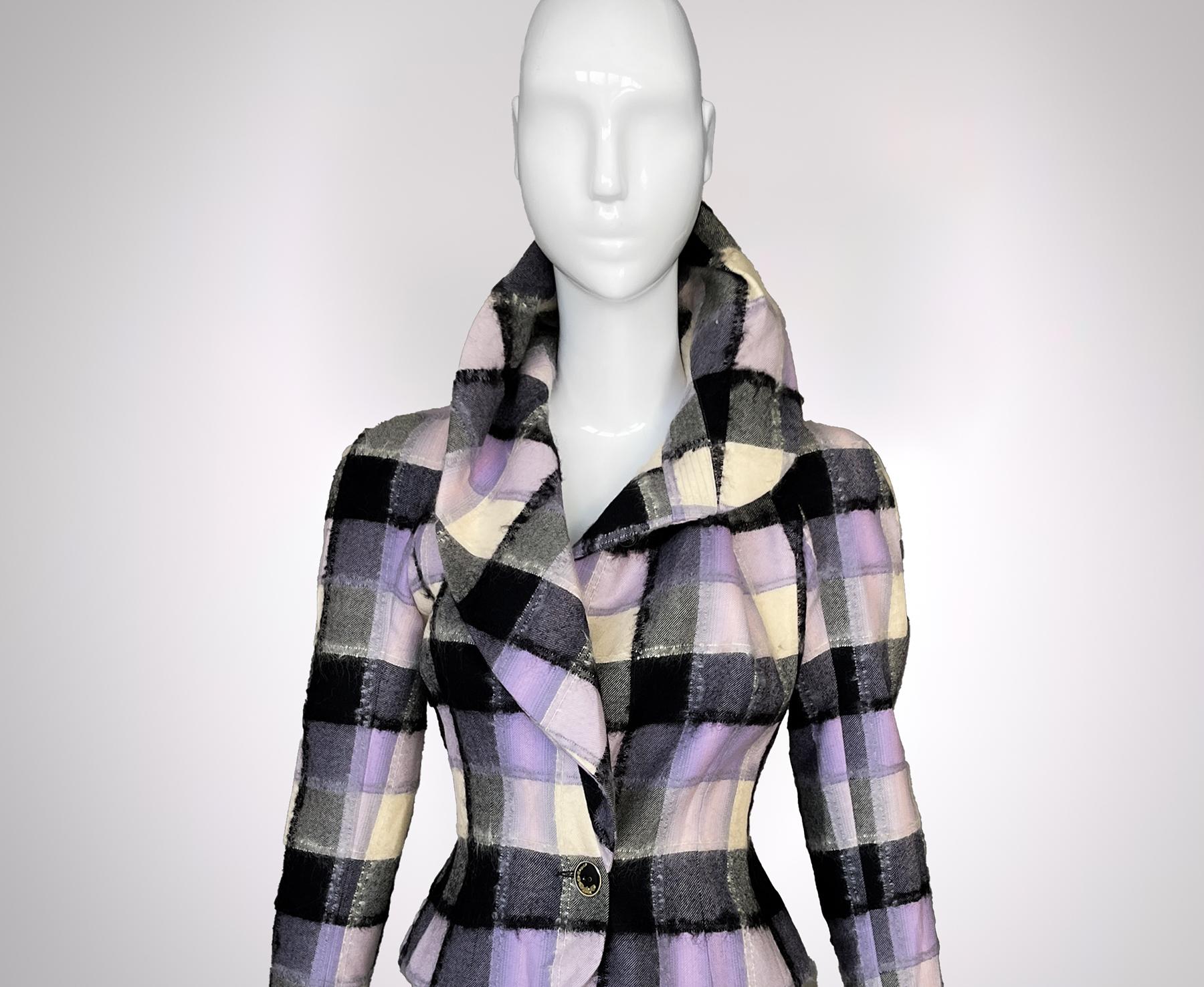 John Galliano’s Sculptural Plaid Masterpiece
A symphony of structure and softness, this John Galliano jacket redefines traditional plaid with a distinctly avant-garde approach. The silhouette is pure Galliano: a sharply tailored hourglass shape that