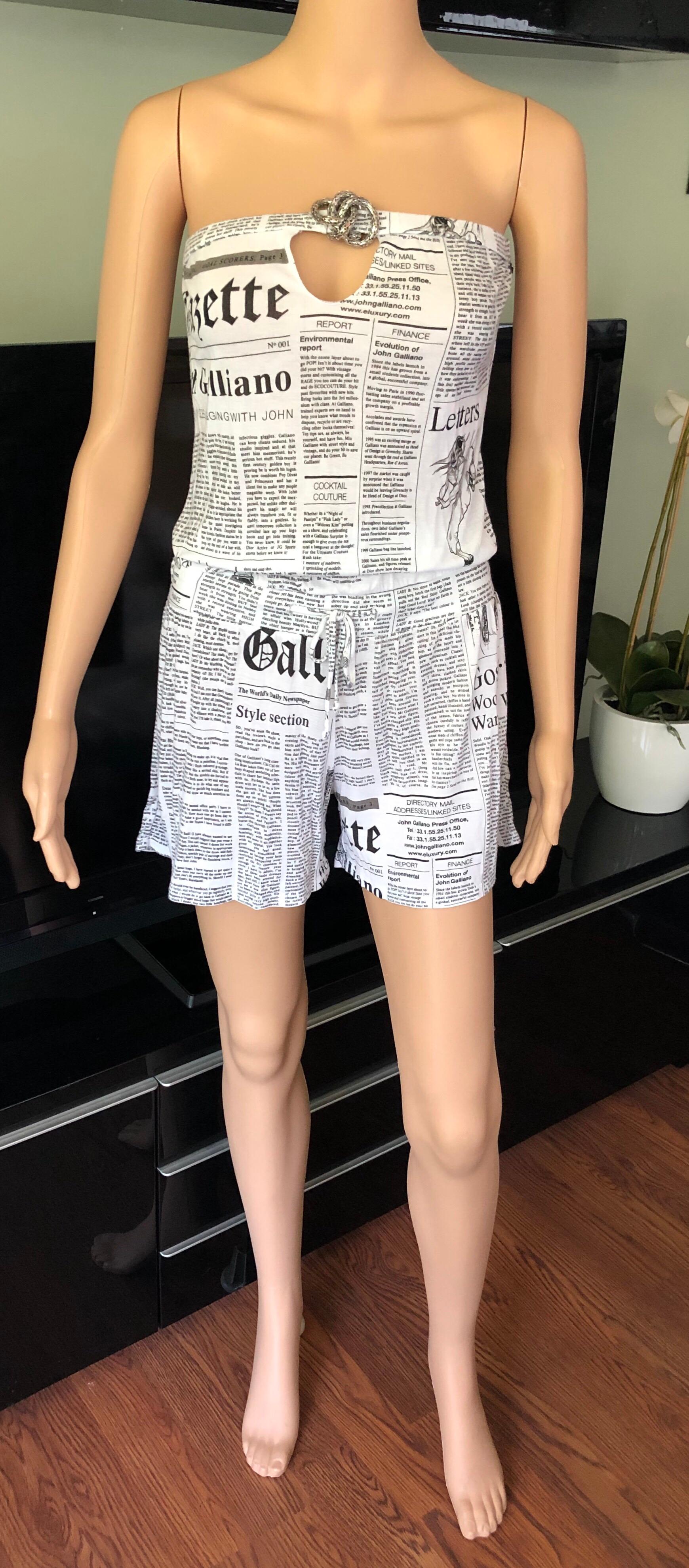 John Galliano romper with newspaper print throughout, silver embellishment at front, and drawstring accent at waist.
