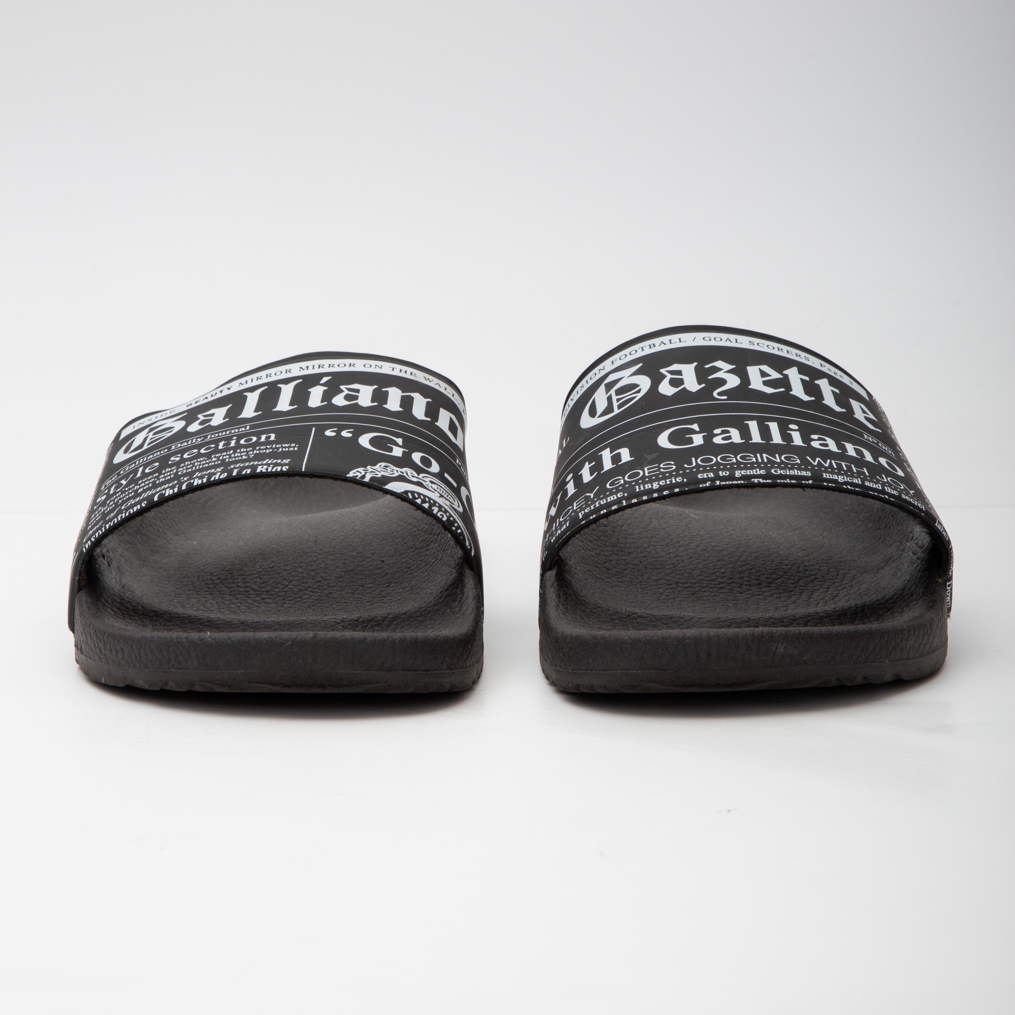 Men's or Women's. Gazette-Print Pool Slides. 

John Galliano Paris pool slides showcasing iconic gazette-print (newspaper print) motif. Featuring a flat heel, an open toe, a single-band vamp, a molded footbed, and an easy slide style.

COLOR: Black