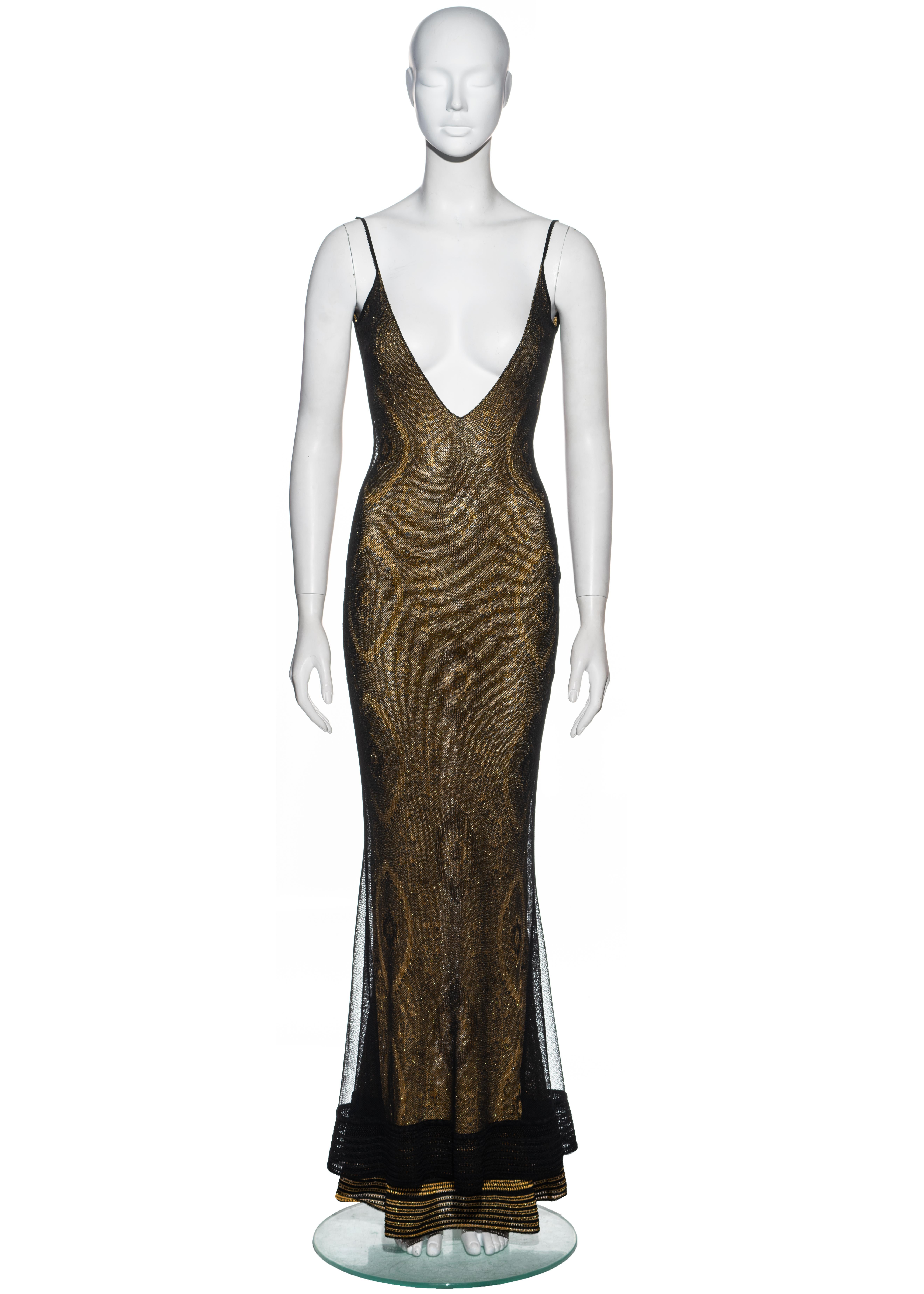 ▪ Vestido de noche John Galliano en jacquard dorado de punto de lúrex
Escote en pico pronunciado 
▪ Revestimiento de malla negra 
▪ Falda de cola de pez 
▪ Parte baja de la espalda 
▪ Se vende con rebeca abotonada a juego 
▪ Talla pequeña
▪