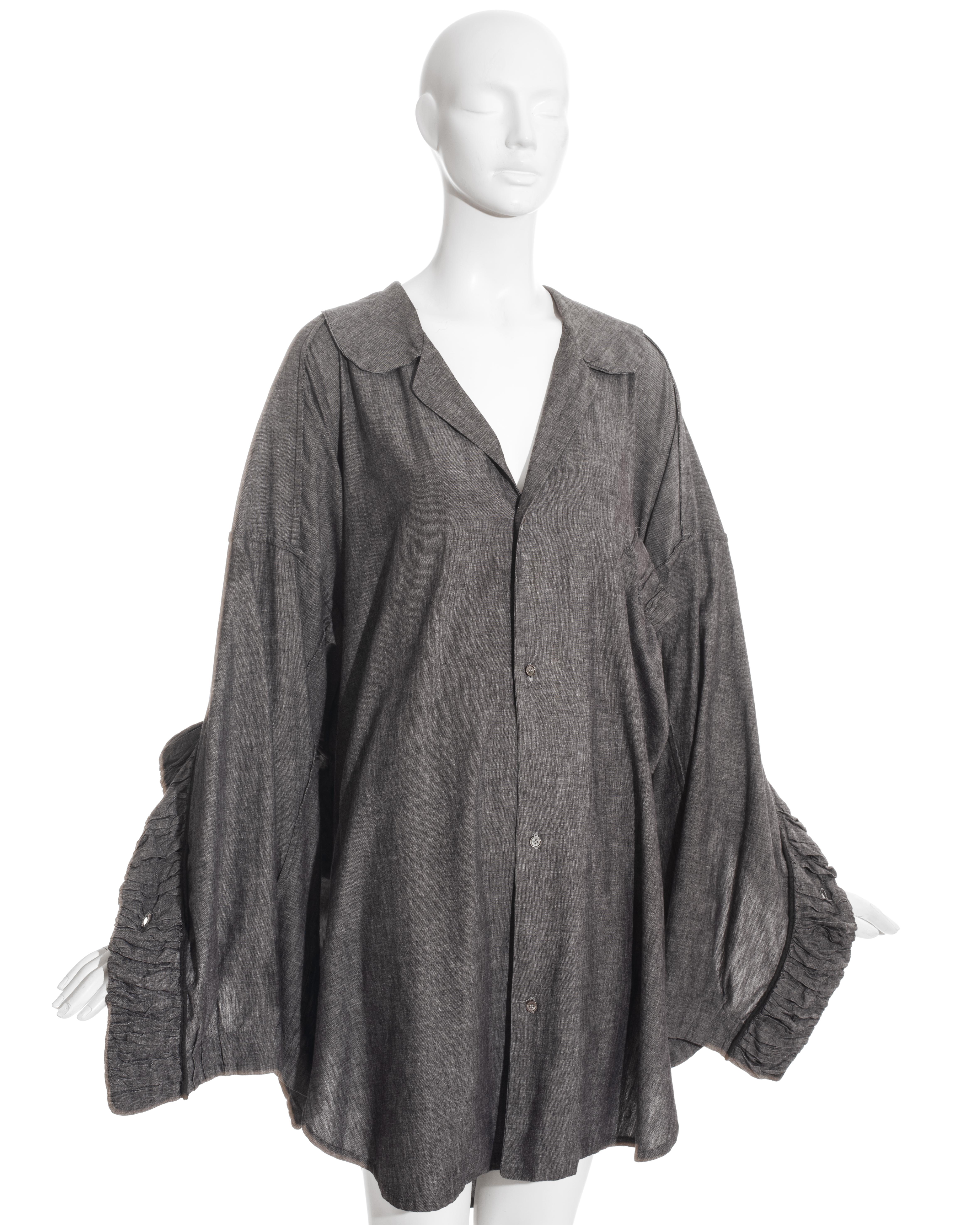 John Galliano grey linen oversized button-up shirt with ruffled trim on cuffs and pocket.

Afghanistan Repudiates Western Ideals, Spring-Summer 1985