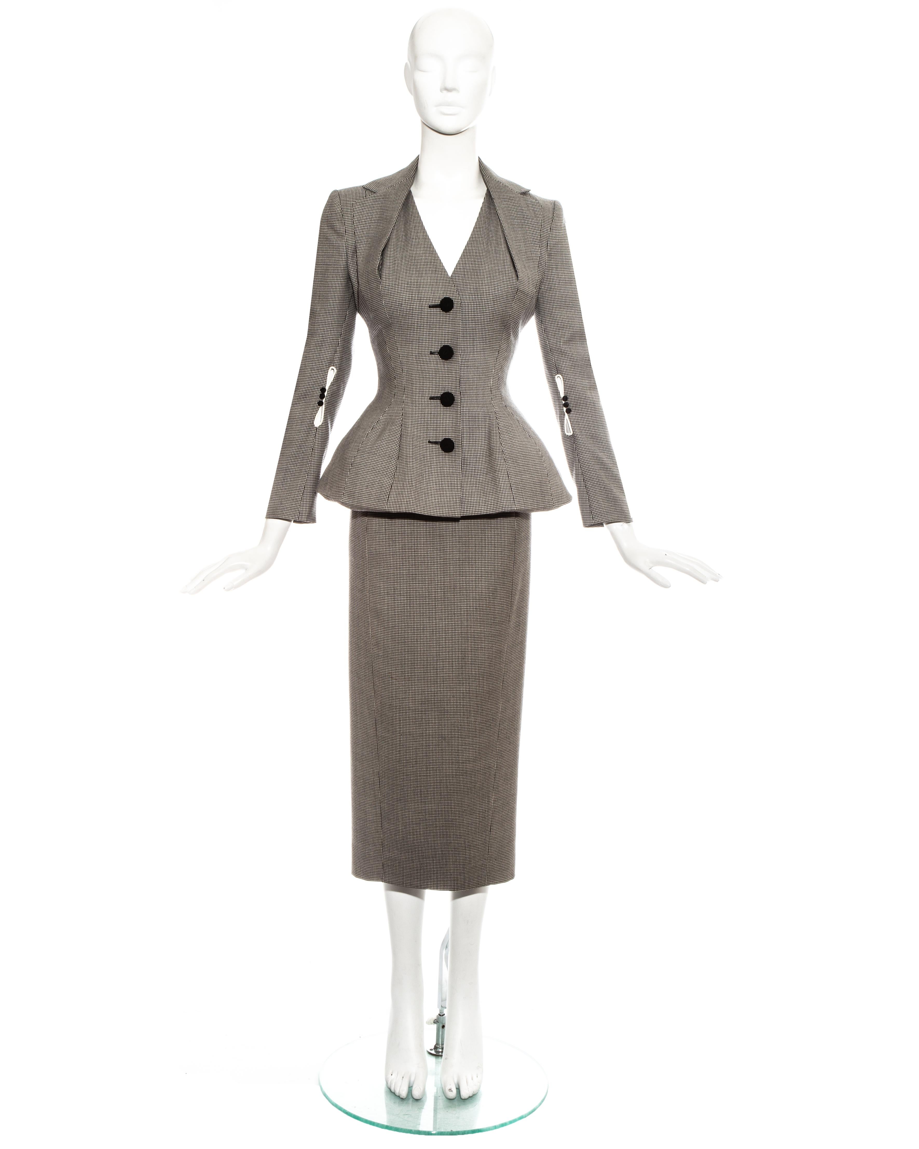 John Galliano; hound's tooth check wool skirt suit. Jacket with padded shoulders, hips and halter-neck style lapel, cord covered buttons. Matching high-waisted pencil skirt. 

Spring-Summer 1995