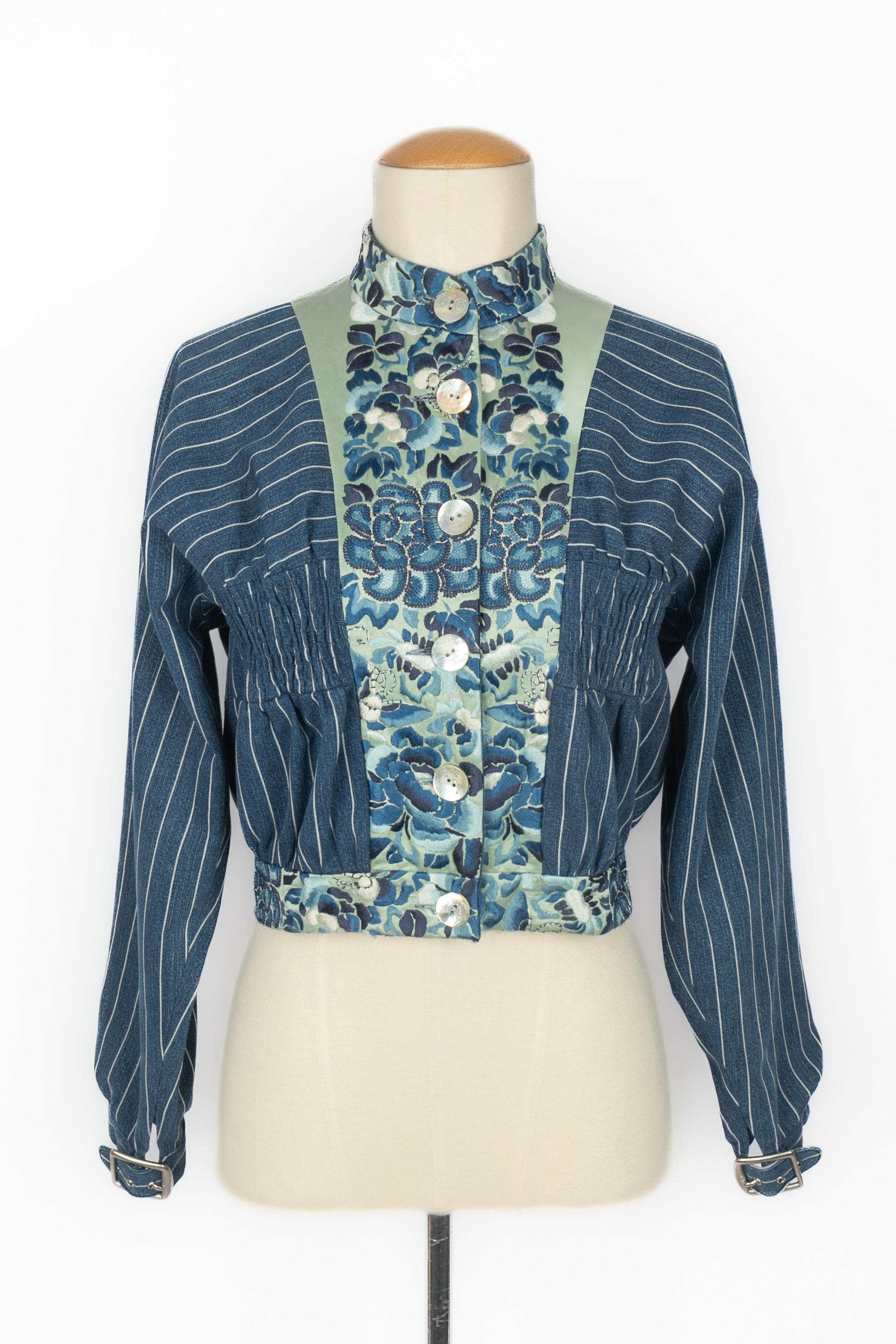 JOHN GALLIANO - Giacca in denim blu con strisce bianche, toppe in raso verde chiaro ricamate con fiori blu. Bottoni perlati in costume. Non è indicata la taglia, ma si adatta a una 34FR/36FR. Una collezione del 1994 circa.

Condizioni:
Ottime