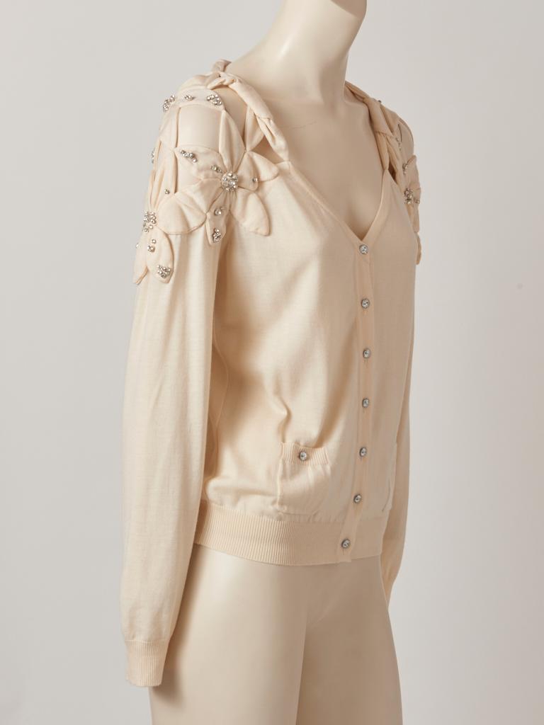 John Galliano, ivory, cashmere and silk knit,  V neck cardigan having rhinestone button closures and decoration with large hand sewn, flower applique details at the shoulders and upper back. Label missing.