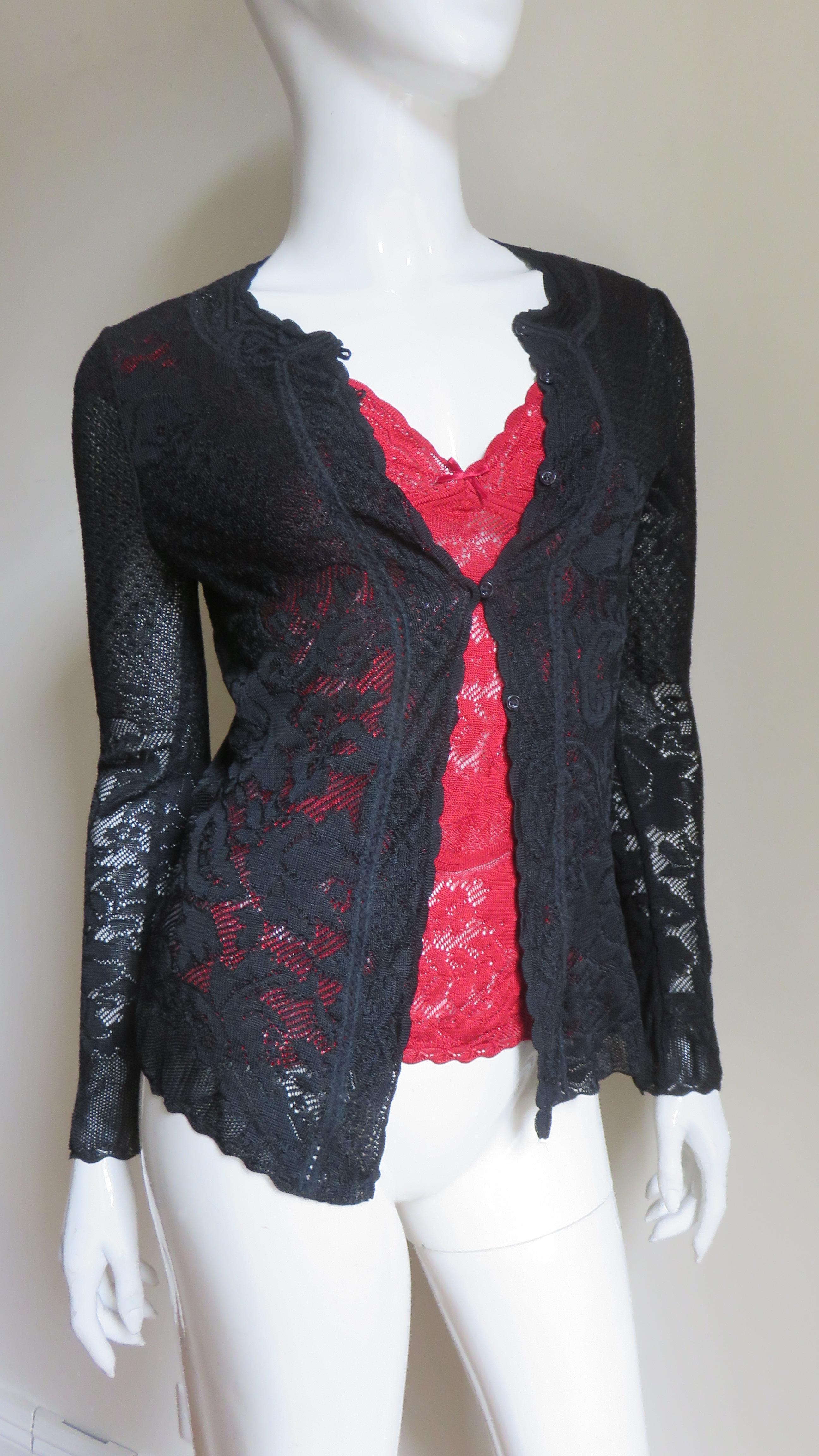 A fabulous cardigan and camisole set in black knit lace plus an additional matching red camisole all from John Galliano. The set consists of 2 flower pattern lace knit camisoles one black and one red with a V neckline and shoulder straps.  The long