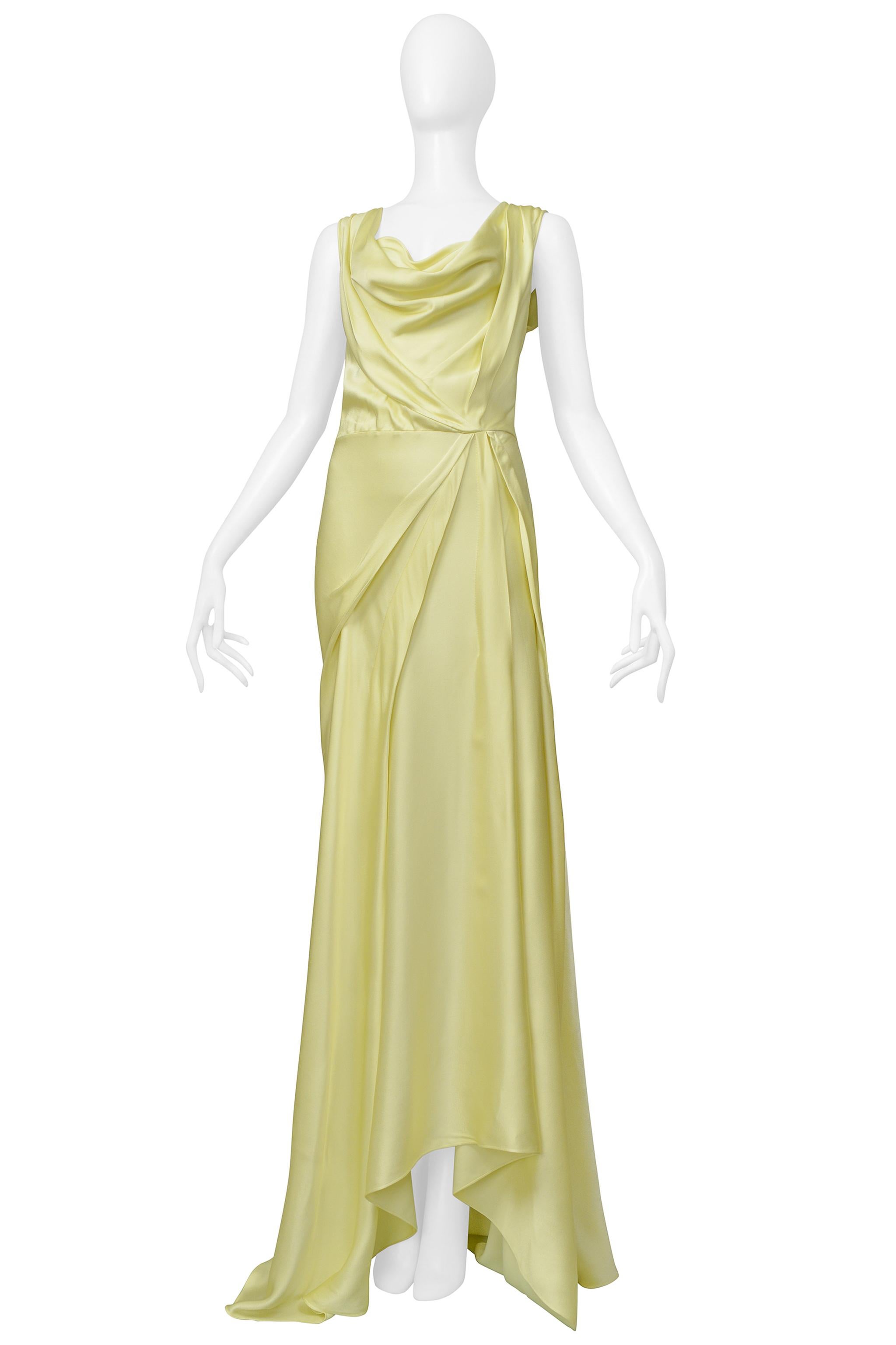 Resurrection is excited to offer a stunning vintage John Galliano lemon meringue yellow satin bias-cut evening gown featuring a plunging neckline with a cowl neckline, asymmetrical draping and pleating at the skirt, a side zipper, and a dramatic
