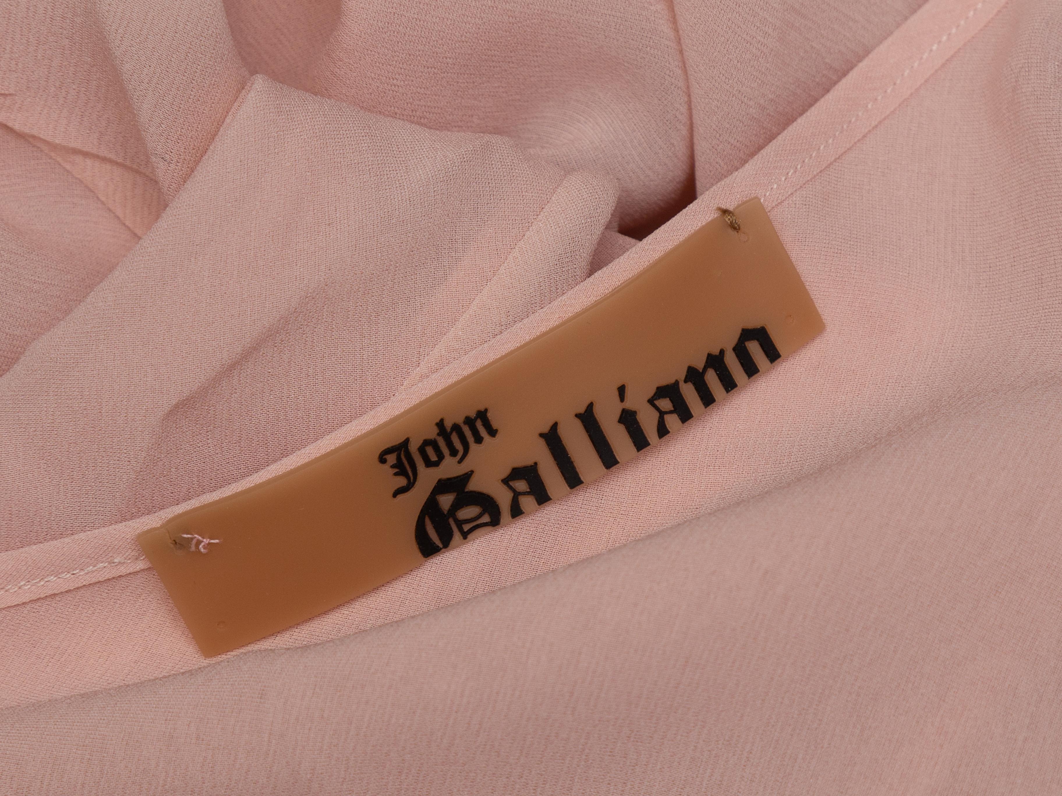 Dettagli prodotto: Gonna midi in seta rosa chiaro di John Galliano. Orlo asimmetrico scanalato. Chiusura con bottoni coperti sul lato. Designer taglia 40. Vita 32