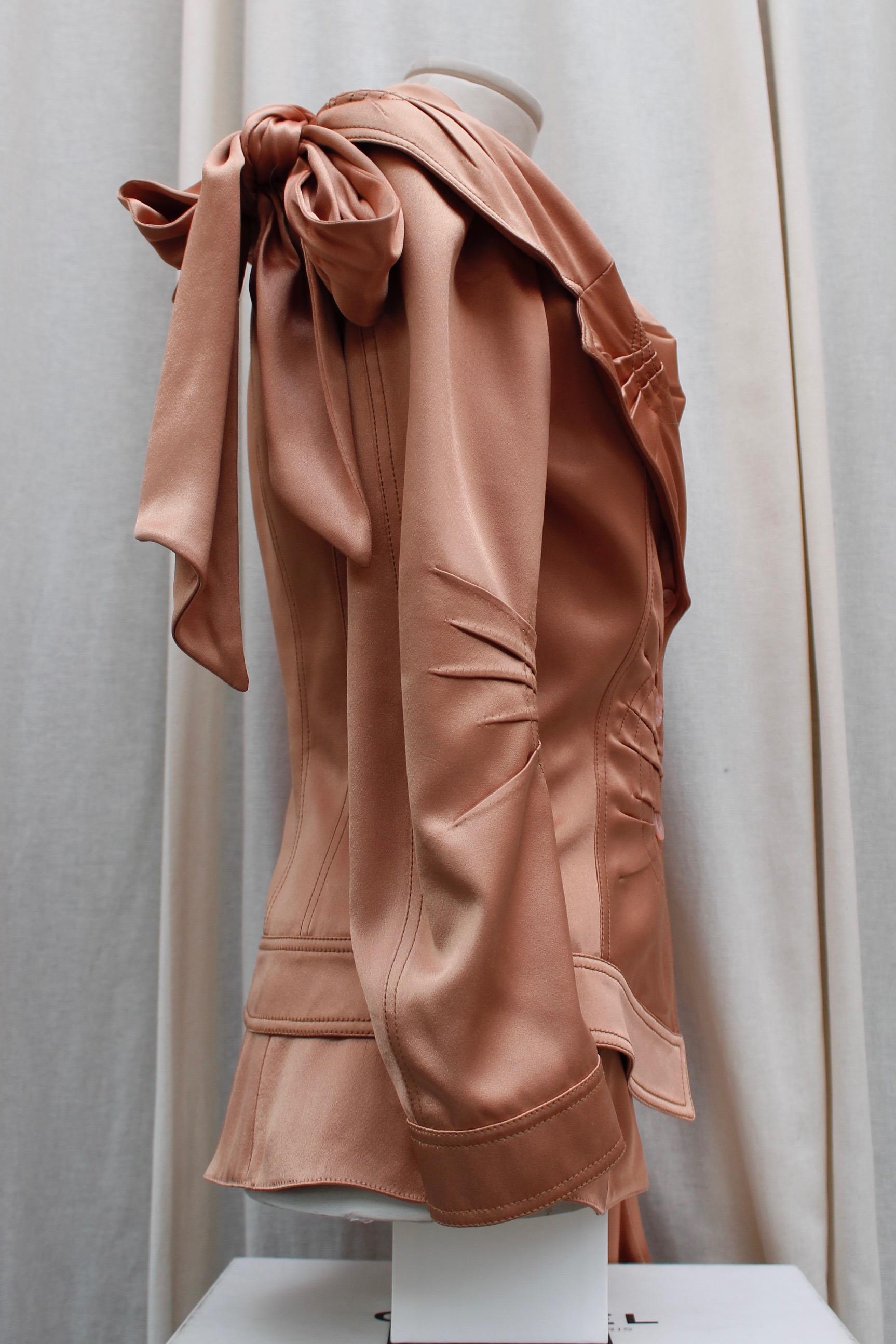 JOHN GALLIANO – Lovely set comprised of a vest and a jacket composed of iridescent powder-pink silk satin. The wrap-cut halter vest features a tailored collar and closes at the waist in pleated draped detailing. One flap pocket.

The jacket cut is