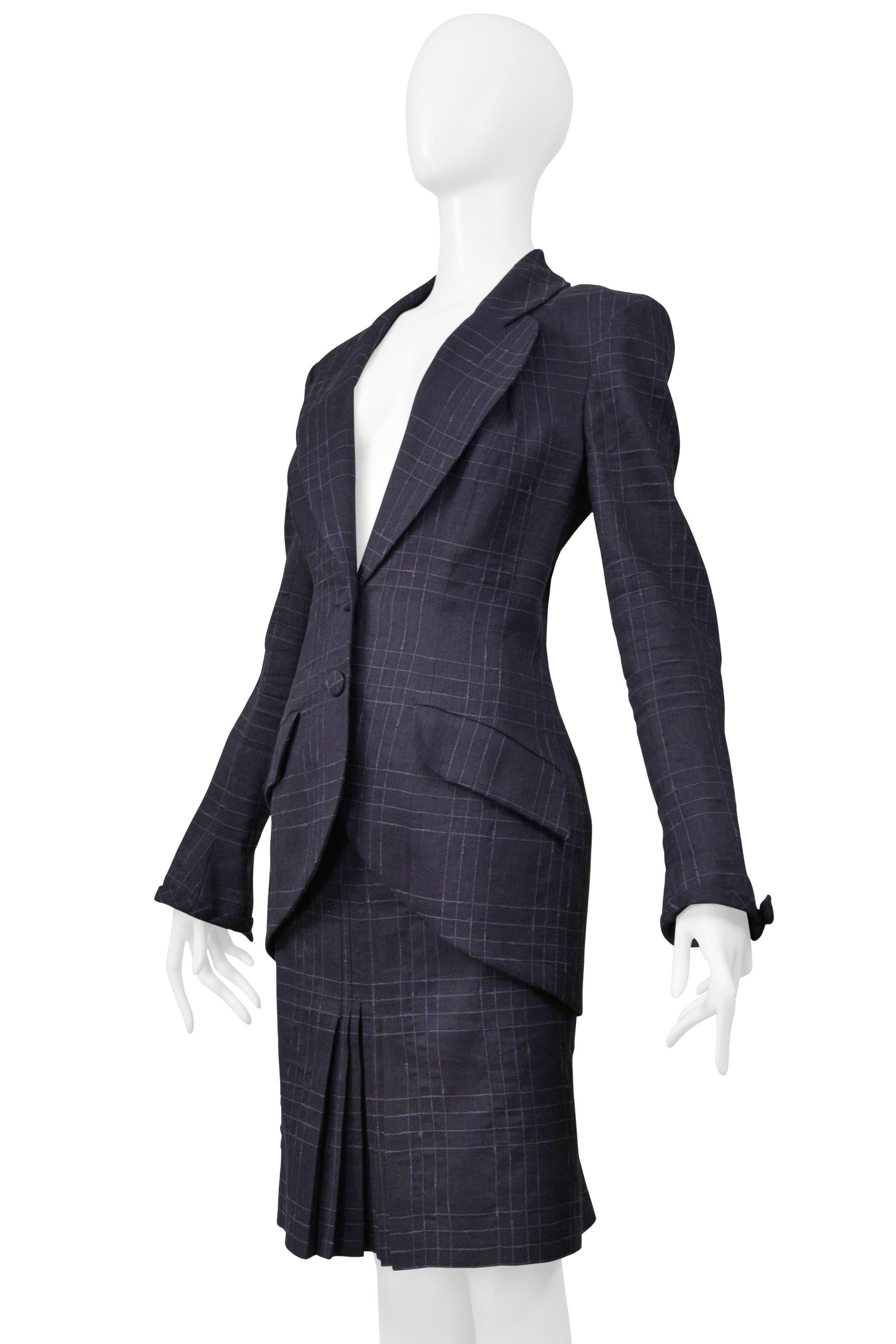 Resurrection Vintage is excited to offer a vintage John Galliano navy windowpane check blue skirt ensemble. The fitted jacket features round lapels, a fitted body, a long silhouette, a two-button closure, decorative covered buttons, and bows at the