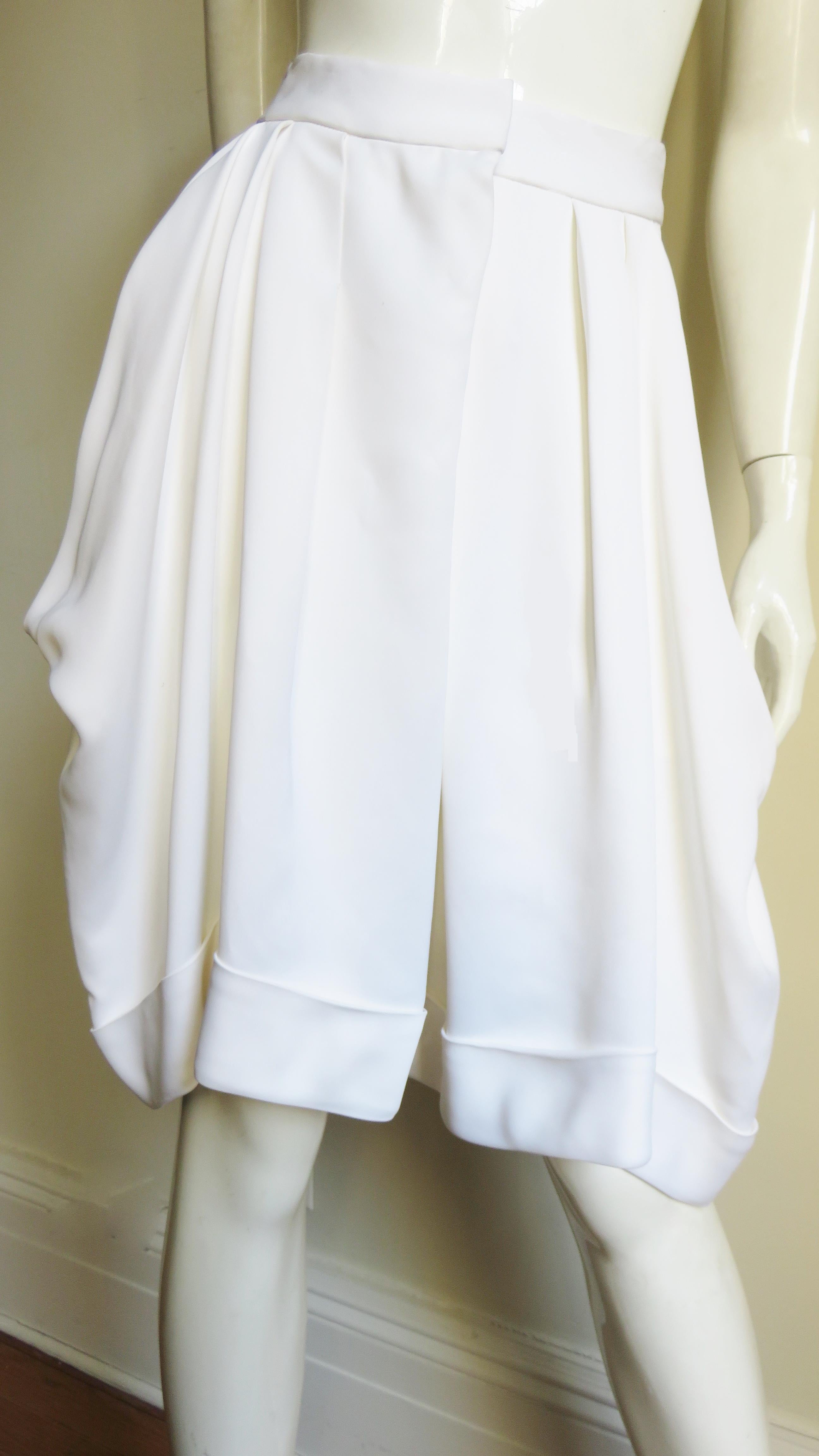 Beautiful white shorts/skirt from John Galliano.  They have a waistband, a cuffed hem, draped side pockets and a front zipper closing.  
Fits sizes Small, Medium. Marked Italian size 40.

Waist  28