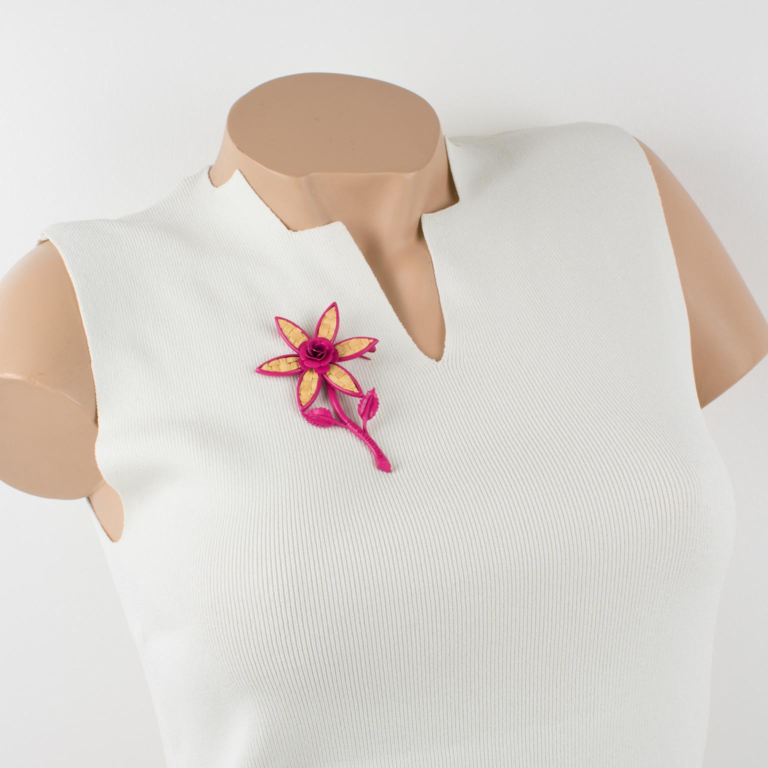 Este magnífico broche John Galliano Paris presenta una forma de flor de margarita sobredimensionada en metal esmaltado de color rosa intenso que contrasta con una inserción de marquetería de paja auténtica. El alfiler tiene un cierre de seguridad y