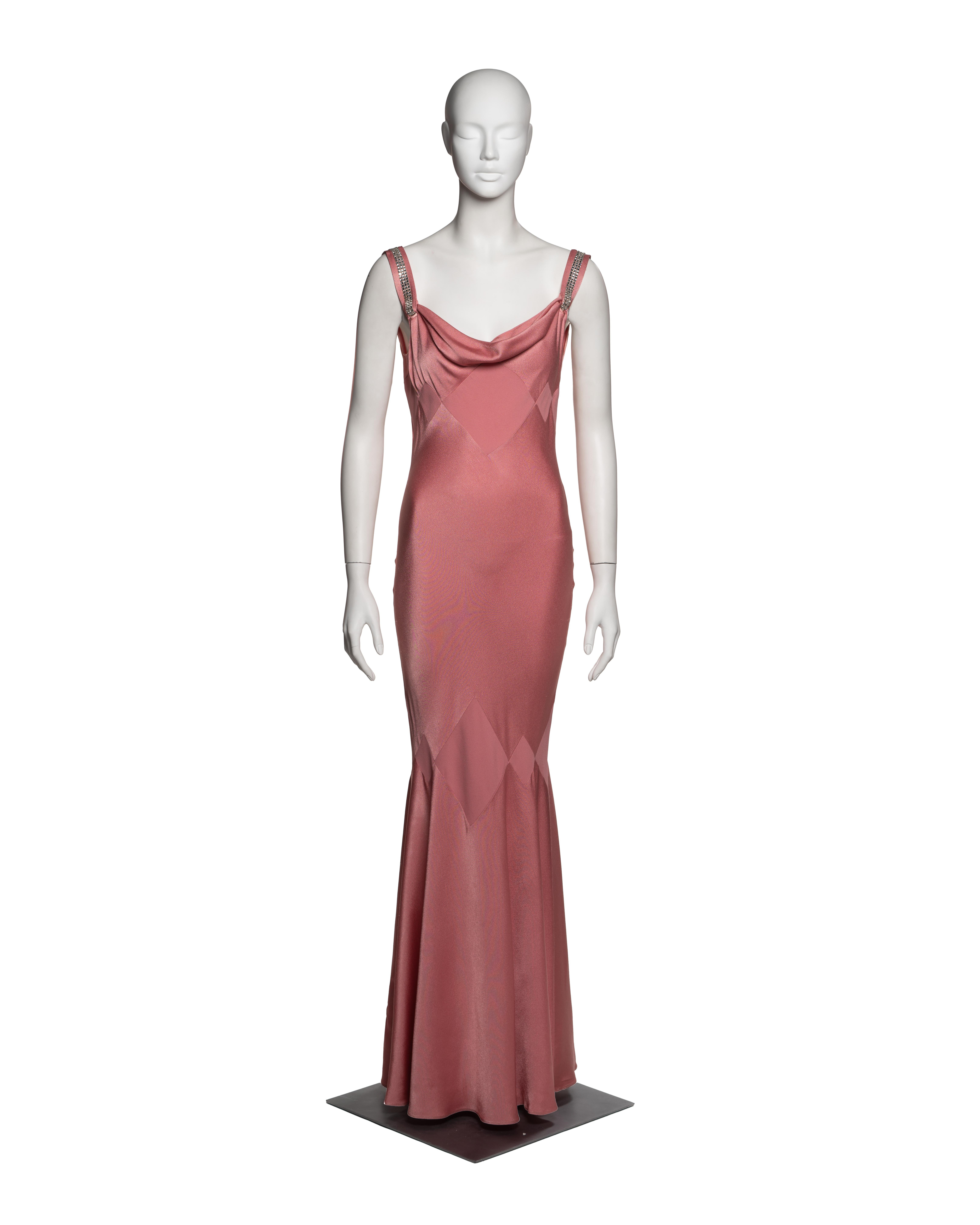 John Galliano, Spring-Summer 2002. Bias-cut evening dress in rose-toned crepe-back satin. The fitted bodice features a draped cowl neckline, with rhinestone-embellished straps. The geometric panel construction incorporates the same fabric in