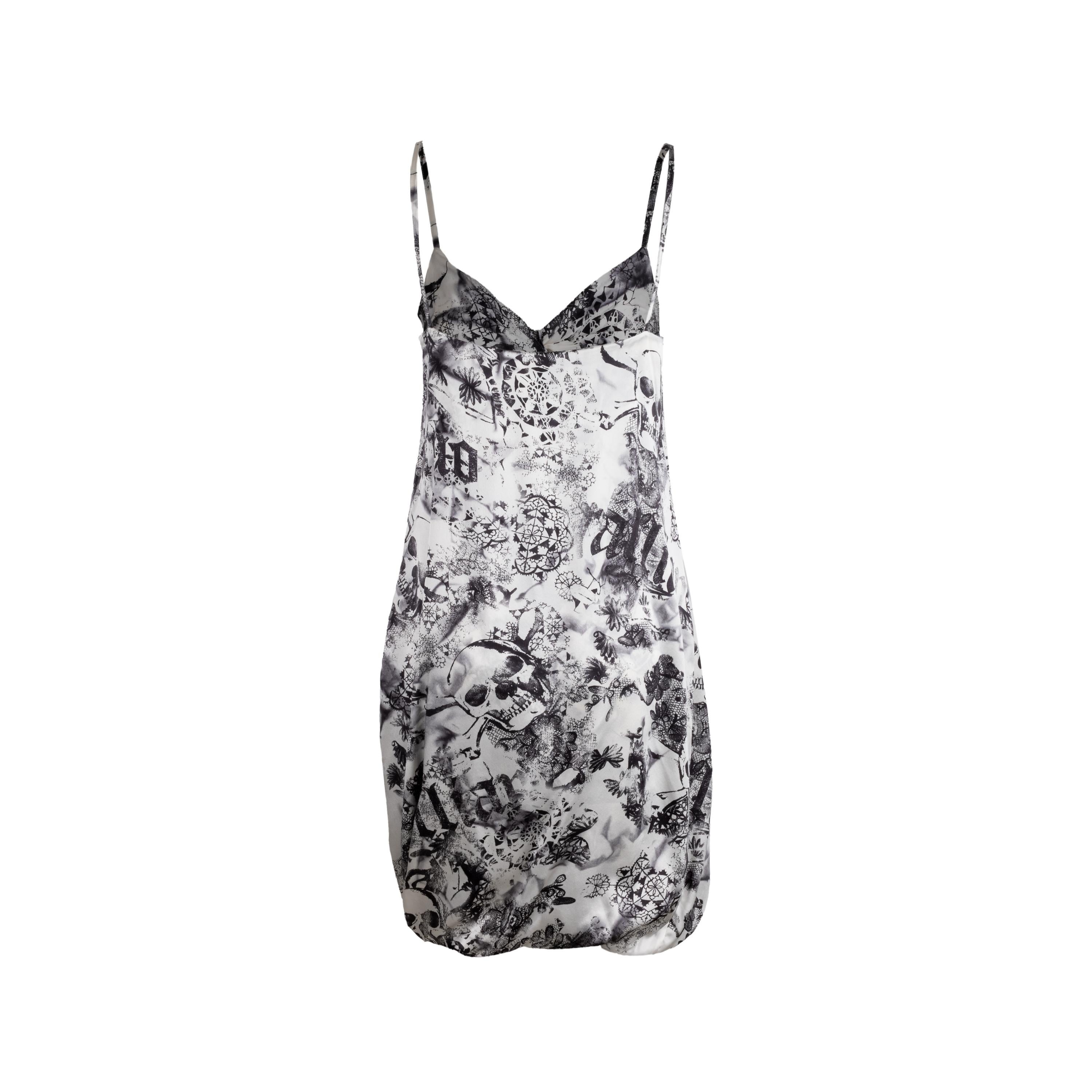 Diseñado por John Galliano, este vestido de seda presenta un exclusivo estampado integral de calaveras y motivos de encaje. El corte corto y los tirantes finos añaden un toque de elegancia, mientras que el estilo de nudo en el pecho le da un toque