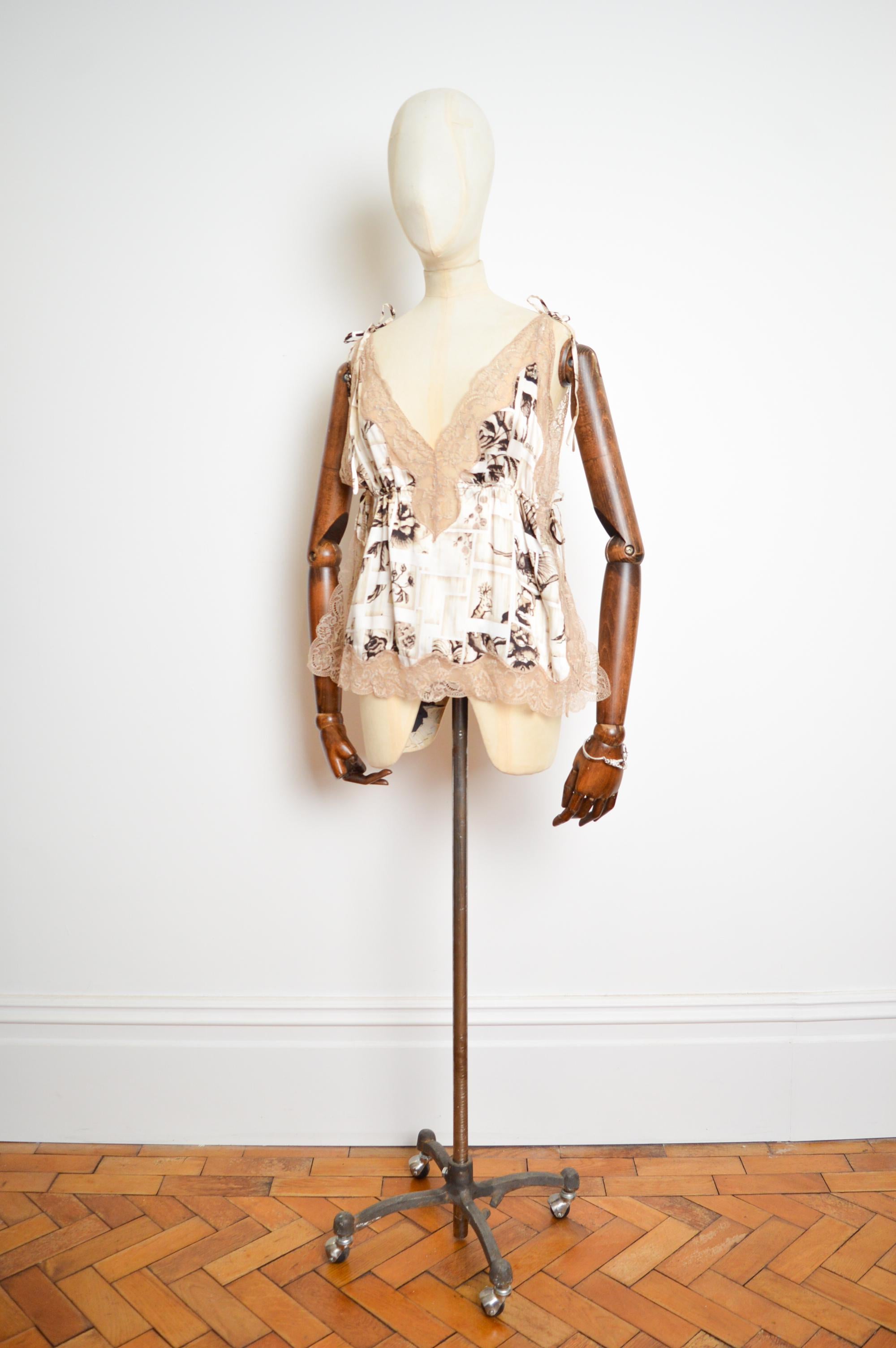 Delicate Nude Silk John Galliano 'Newspaper' print camisole with fine chantilly lace trimmed sheer edges and details in an antique cream. 
(Spring 2011).

MADE IN ITALY.   

Measurements are provided in Inches:  
Under bust ; 18