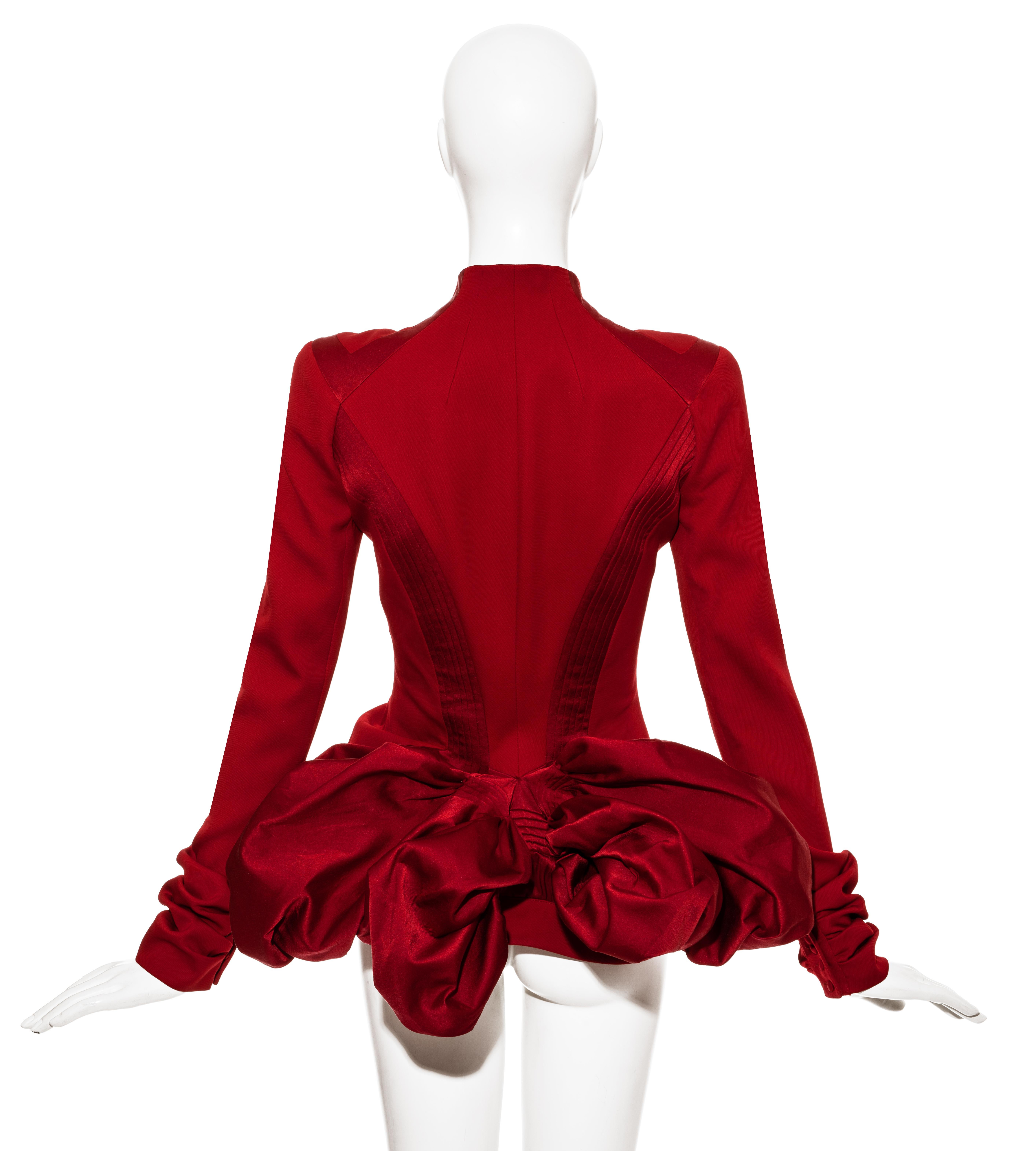 John Galliano red wool evening jacket with voluminous bustle, bias cut satin panels, fabric covered buttons, and ruched seams around hips and cuffs. 

Fall-Winter 2003