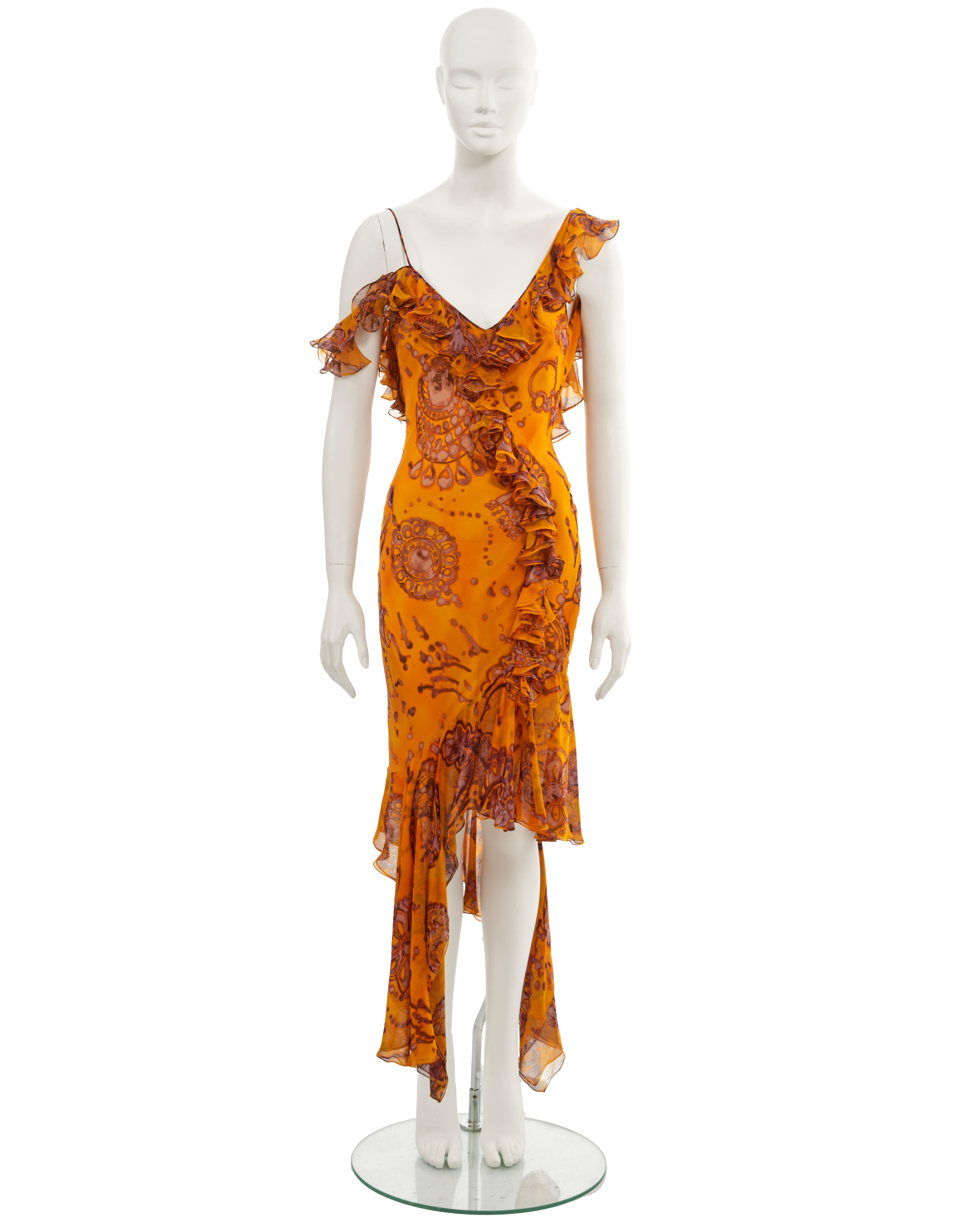 ▪ John Galliano evening dress
▪ Spring-Summer 2003
▪ Sold by One of a Kind Archive
▪ Crafted from silk chiffon in a vibrant saffron hue, featuring a batik-dyed outsized paisley print
▪ The neckline, shoulder straps, and bodice are adorned with a