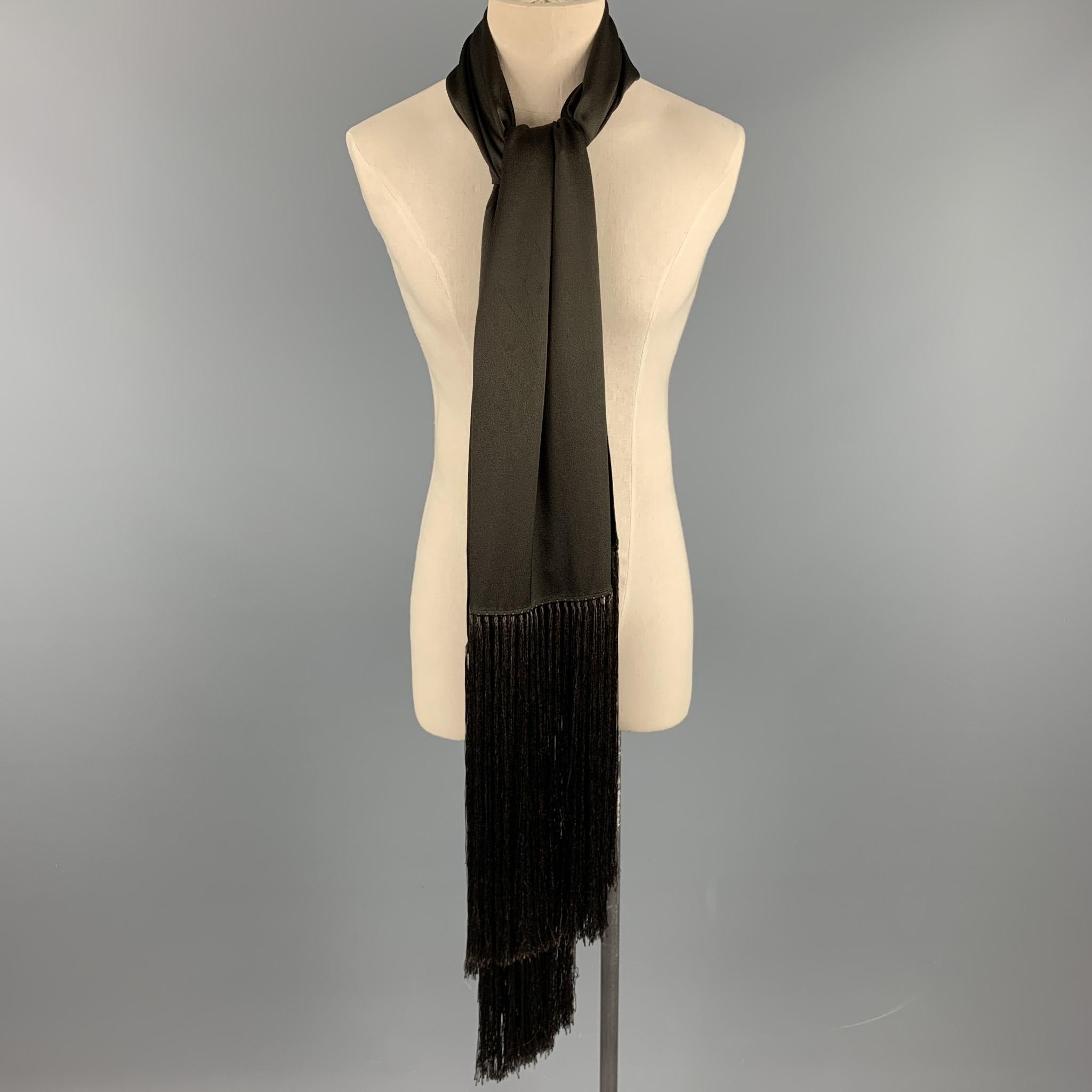 JOHN GALLIANO scarf comes in a brown solid fabric with sixteen and a half fringe trim. 

Excellent Pre-Owned Condition.

Measurements:

70 in. x 27 in. 