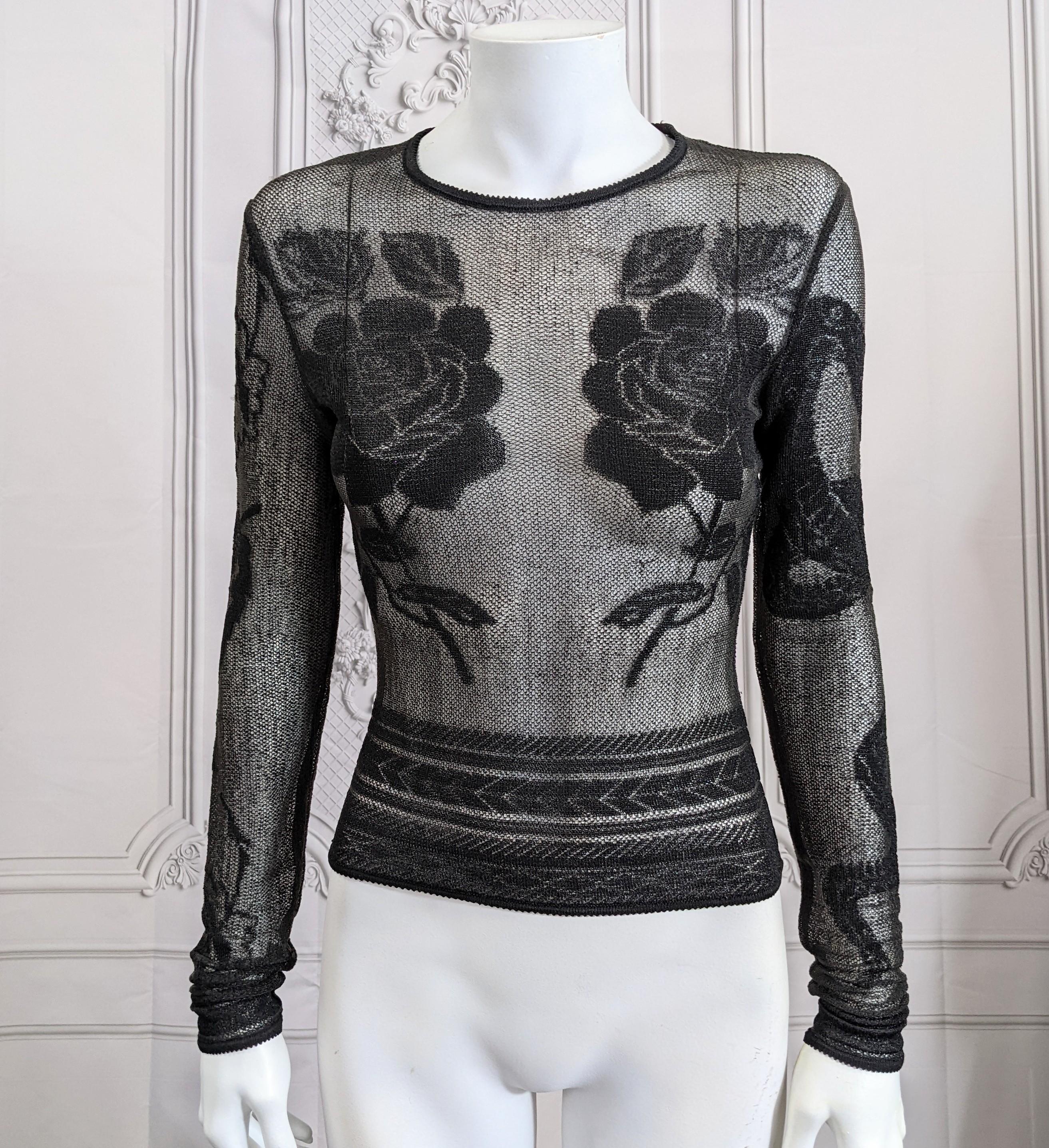 John Galliano F/W 1997/98 sheer transparent tinsel faux tattoo knit pullover from Galliano's Suzie Sphinx collection. The black lurex crew neck pullover's displaying front motifs of large roses, the back with crisscrossing American and Union jack