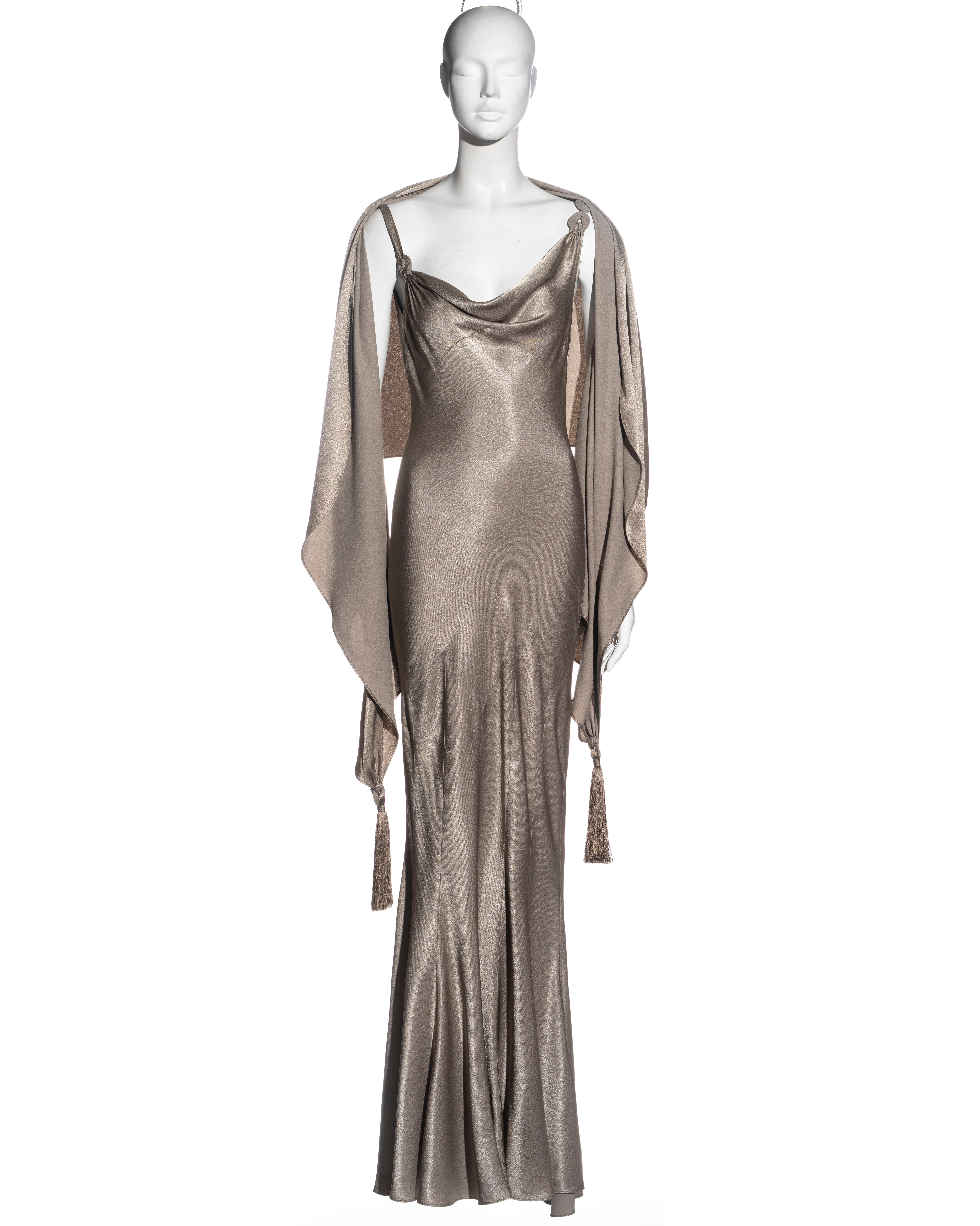 ▪ John Galliano evening dress and shawl 
▪ Taupe crepe satin
▪ Asymmetric cowl neck 
▪ Bias-cut
▪ Multi-panelled floor-length skirt 
▪ Matching shawl with thread tassels 
▪ FR 38 - UK 10 - US 4
▪ Spring-Summer 2000
▪ 68% Acetate, 32% Viscose 
▪ Made